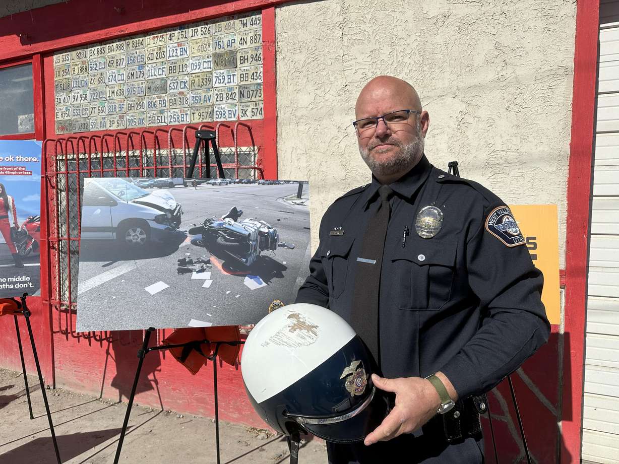 West Valley City police officer Dana Pugmire poses with a photo of his accident and the helmet he was wearing during the collision at a launch for the Utah Department of Public Safety’s new campaign for motorcycle safety, "Meet in the Middle," at Boneyard in West Valley City on Wednesday.
