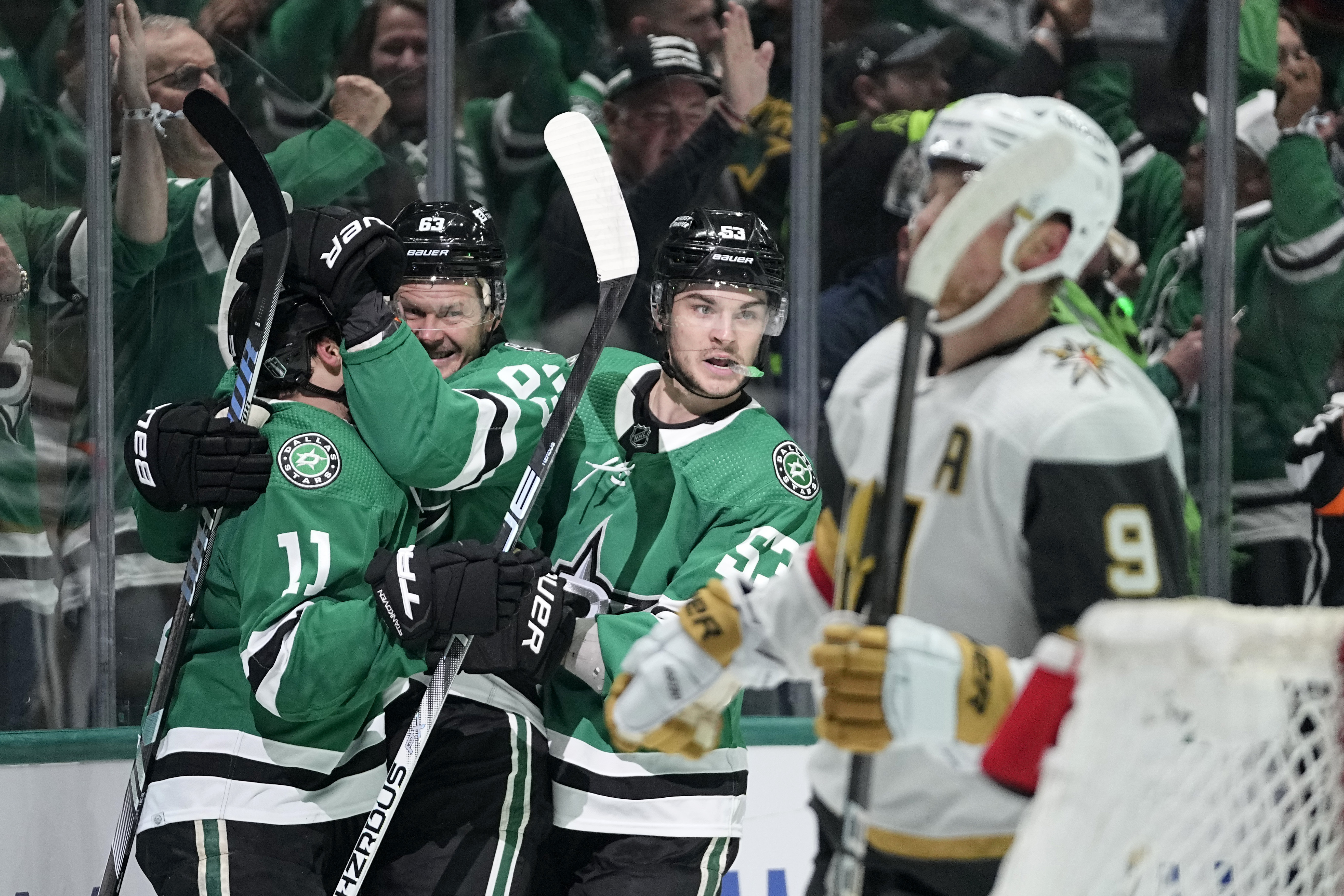 Dallas Stars' Logan Stankoven (11), Evgenii Dadonov, second from left, and Wyatt Johnston (53) celebrate a goal by Dadonov as Vegas Golden Knights' Jack Eichel (9) skates past in the first period in Game 5 of an NHL hockey Stanley Cup first-round playoff series in Dallas, Wednesday, May 1, 2024.