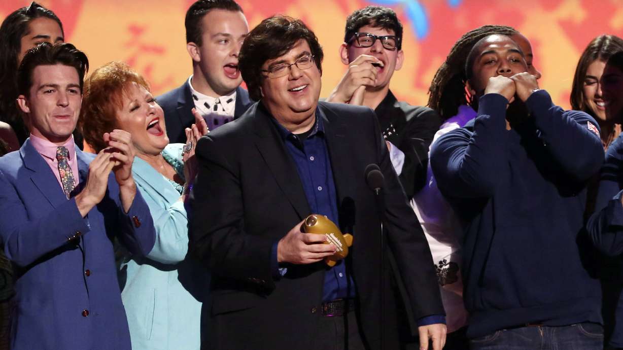 Dan Schneider, center, accepts an award in Los Angeles. Schneider sued the makers of “Quiet on Set: The Dark Side of Kids TV” on Wednesday, alleging the makers of the documentary series wrongly implied that he sexually abused child actors.