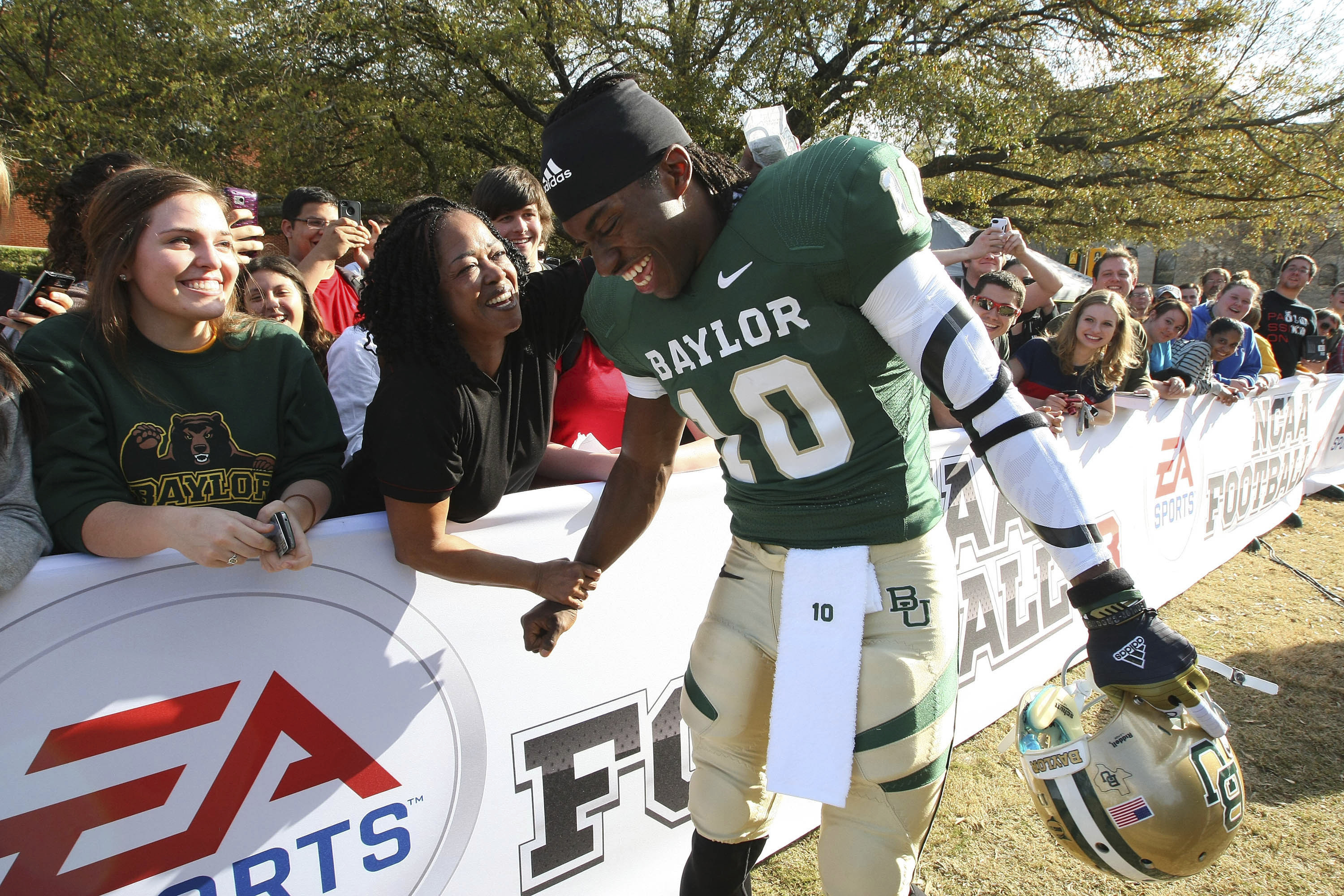Heisman Trophy-winner and former Baylor quarterback Robert Griffin III is greeted by Holly Johnson on the Baylor campus, Monday, Feb. 27, 2012, in Waco, Texas, where he posed for photos for EA Sports NCAA Football 13 video game to be released in July. Video-game developer EA Sports is breaking back into the college football world 11 years after lawsuits over using players’ likeness without compensation froze the franchise.