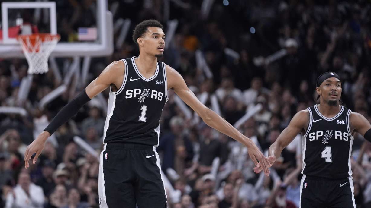San Antonio Spurs center Victor Wembanyama (1) celebrates a score with guard Devonte' Graham (4) during the second half of an NBA basketball game against the Denver Nuggets in San Antonio, Friday, April 12, 2024.