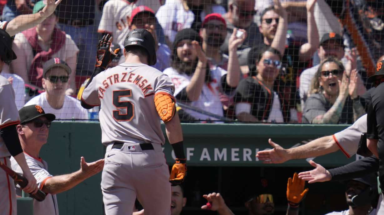 San Francisco Giants' Mike Yastrzemski (5) is congratulated after his solo home run during the third inning of a baseball game against the Boston Red Sox at Fenway Park, Thursday, May 2, 2024, in Boston.
