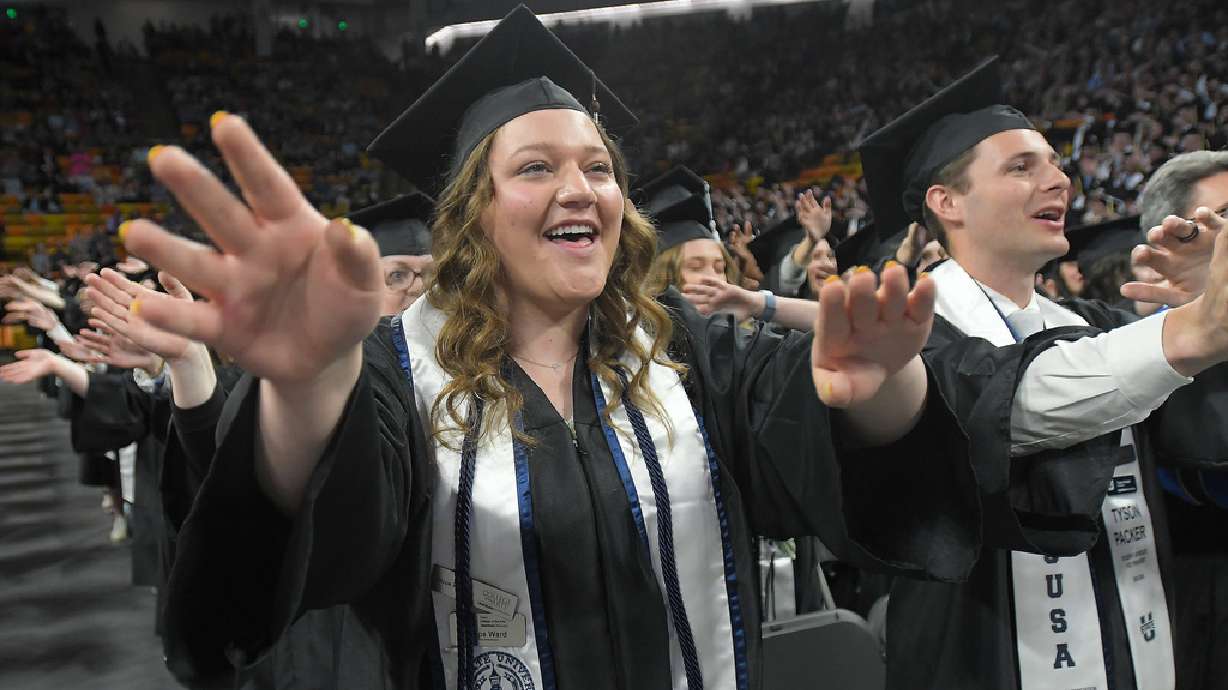 Hope Ward, left, and Tyson Packer celebrate during the commencement ceremony at Utah State University on Thursday in Logan.