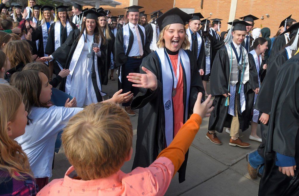 Elementary school students congratulate graduates as they walk across the Utah State University campus to attend the commencement ceremony on Thursday in Logan.