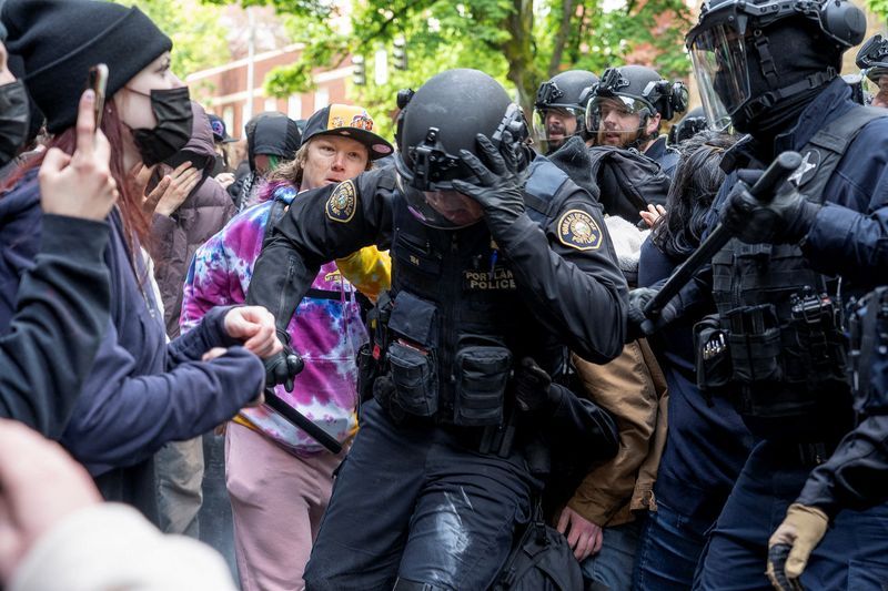 Police officers scuffle with protesters trying to block vehicles taking detained students, who had been occupying the Portland State University Library building, during the ongoing conflict between Israel and the Palestinian Islamist group Hamas, in Portland, Oregon Thursday.