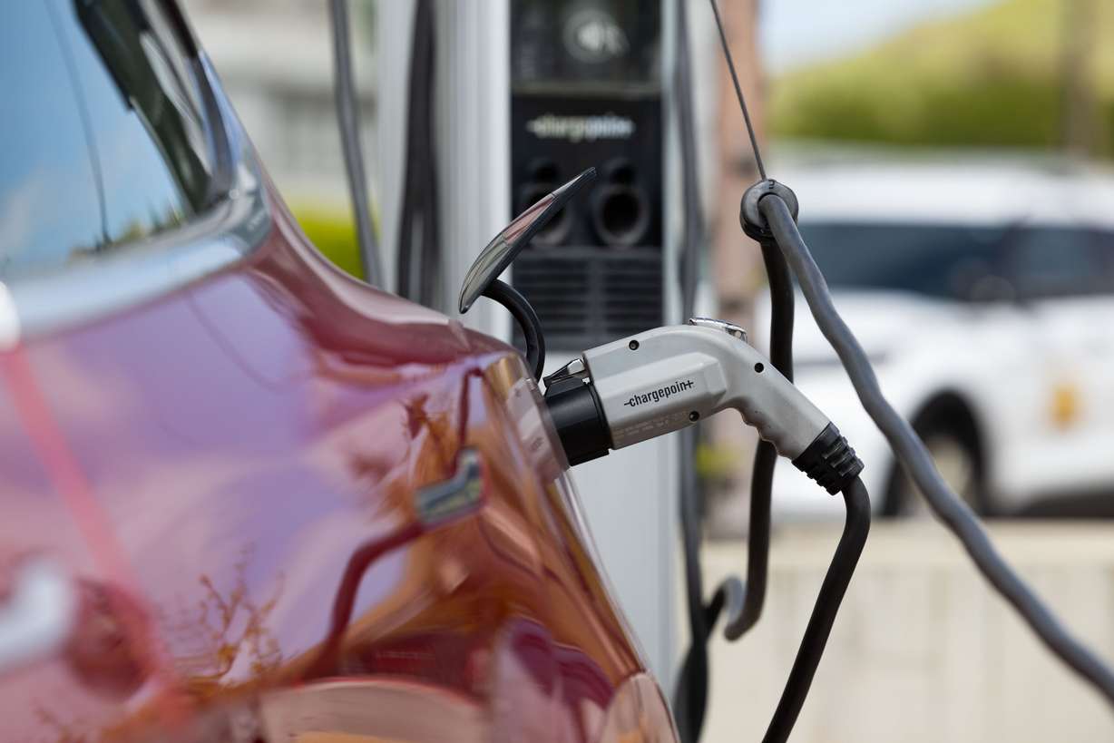 A car is plugged into an electric charging station outside of the Utah State Capitol in Salt Lake City on Thursday. Sen. Mitt Romney, R-Utah, joined a bipartisan and bicameral group of colleagues to block President Joe Biden’s electric vehicle mandates.