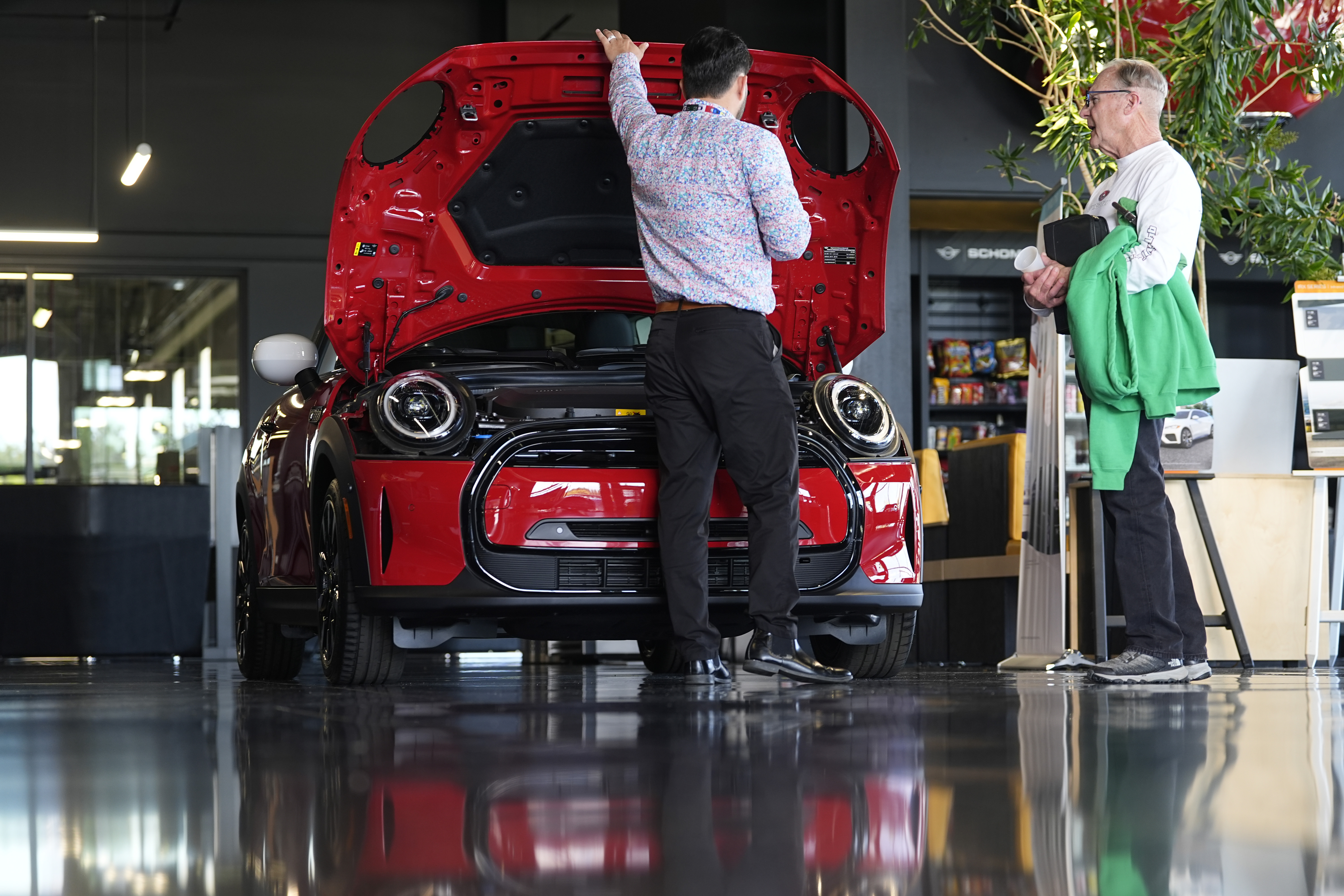 A salesperson shows an unsold 2024 Cooper SE electric hardtop at a dealership Wednesday in Highlands Ranch, Colo. U.S. employers scaled back hiring in April but still added 175,000 jobs, the government said Friday.