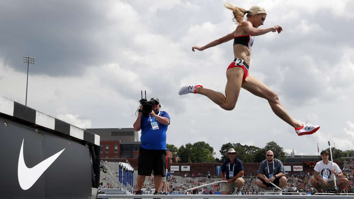 FILE - Emma Coburn leaps over the water pit during the women's 3,000-meter steeplechase at the U.S. Championships athletics meet, on June 23, 2018, in Des Moines, Iowa. Three-time U.S. Olympian Emma Coburn says her “dream of Paris is over” after breaking her ankle at the Diamond League meet in Shanghai and undergoing surgery.