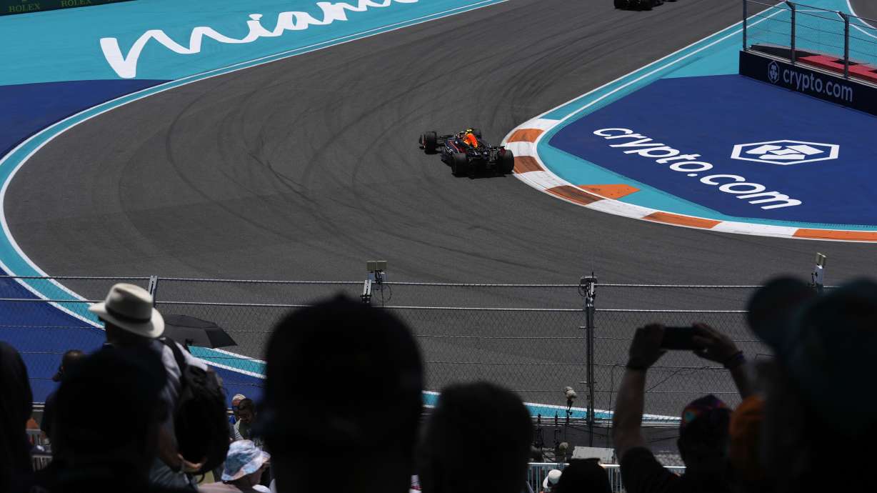Fans watch from a grandstand as Red Bull driver Sergio Perez of Mexico, center, and Mercedes driver Lewis Hamilton of Britain drive past during the practice session for the Formula One Miami Grand Prix auto race, Friday, May 3, 2024, in Miami.