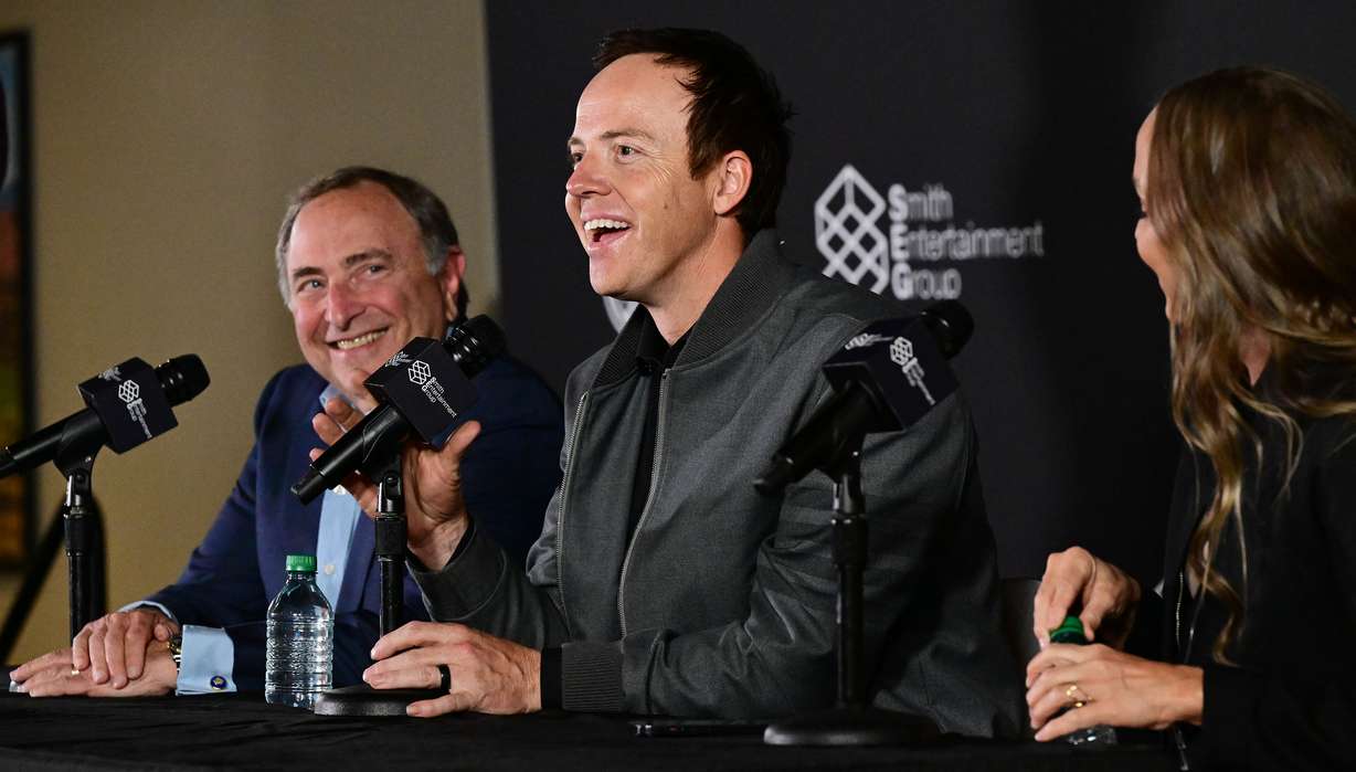 Ryan Smith, co-founder and chairman of Smith Entertainment Group, Ashley Smith, co-founder of Smith Entertainment Group, and NHL Commissioner Gary Bettman attend a press conference at the Delta Center in Salt Lake City to announce that the NHL would be coming to Utah on April 18.