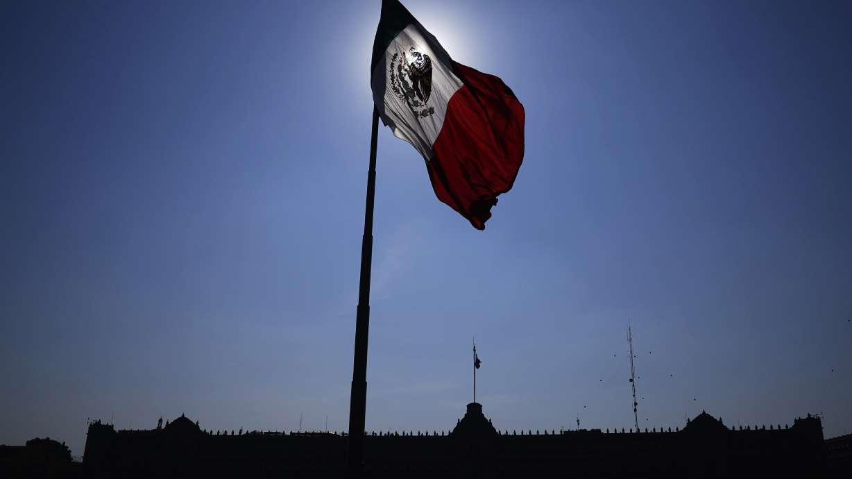 A Mexican flag waves in front of the National Palace in Mexico City's main square, the Zocalo, on April 24, 2023. The Mexican Senate approved a change to make it easier for U.S.-born kids of Mexicans to register their Mexican citizenship.