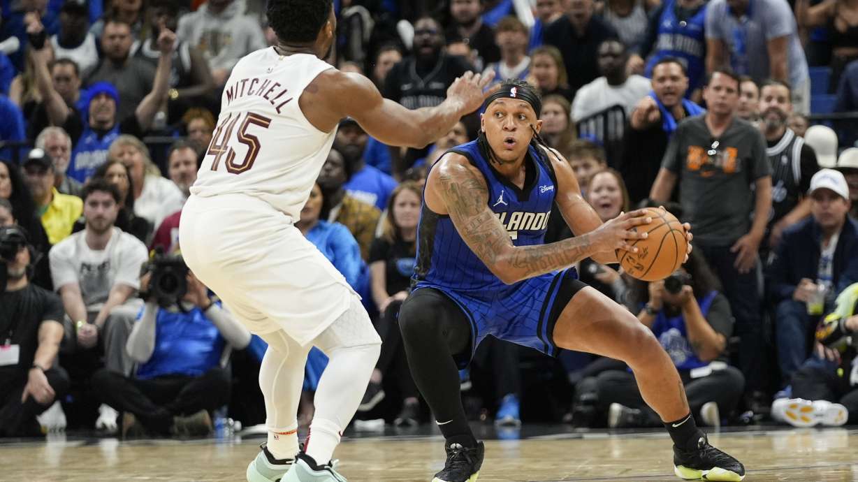 Orlando Magic forward Paolo Banchero, right, grabs a loose ball in front of Cleveland Cavaliers guard Donovan Mitchell (45) during the second half of Game 6 of an NBA basketball first-round playoff series, Friday, May 3, 2024, in Orlando, Fla.