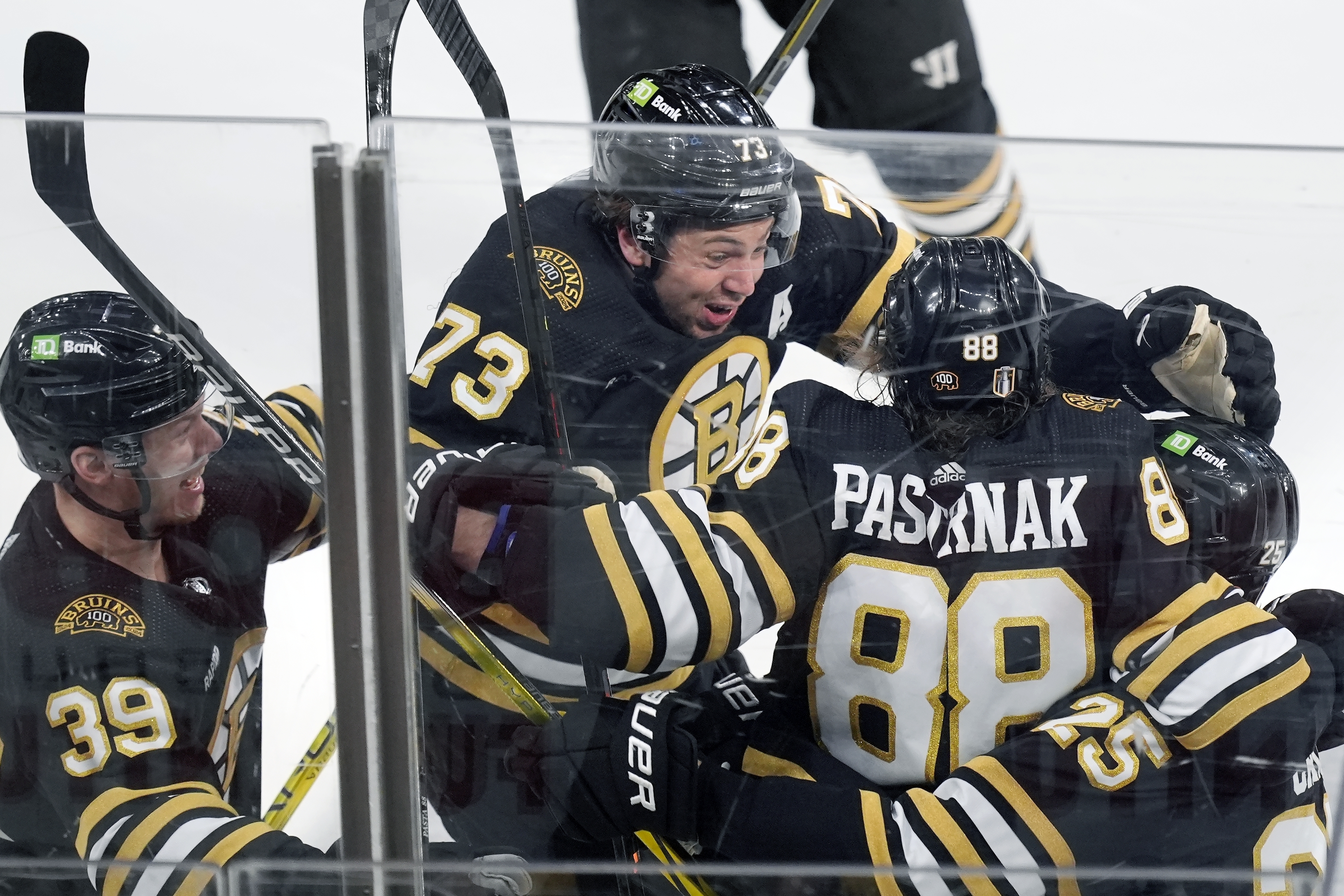 Boston Bruins' David Pastrnak (88) celebrates his goal with Morgan Geekie (39), Charlie McAvoy (73) and Brandon Carlo (25) in overtime during Game 7 of an NHL hockey Stanley Cup first-round playoff series against the Toronto Maple Leafs, Saturday, May 4, 2024, in Boston.