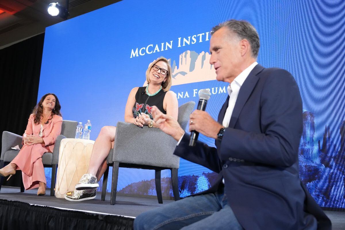 Washington Post reporter Yvonne Wingett Sanchez, left, speaks to Sen. Kyrsten Sinema, I-Ariz., center, and Sen. Mitt Romney, R-Utah, right, at the McCain Institute's Sedona Forum in Sedona, Ariz., on May 3. Romney had high praise for Sinema for her bipartisan efforts.