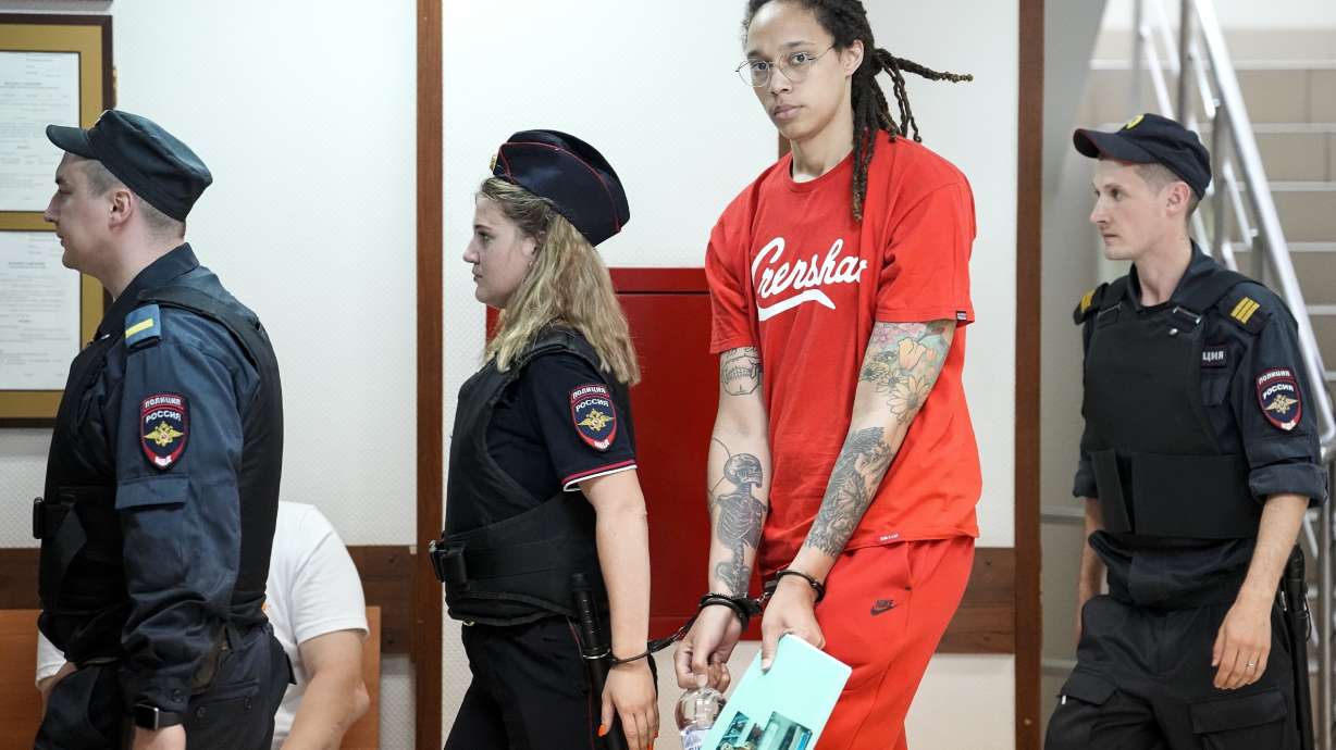 FILE - WNBA star and two-time Olympic gold medalist Brittney Griner, second from right, is escorted to a courtroom for a hearing in Khimki outside Moscow, Russia, July 7, 2022. Griner continues her efforts to settle into a normal routine following her release from a Russian prison 17 months ago.
