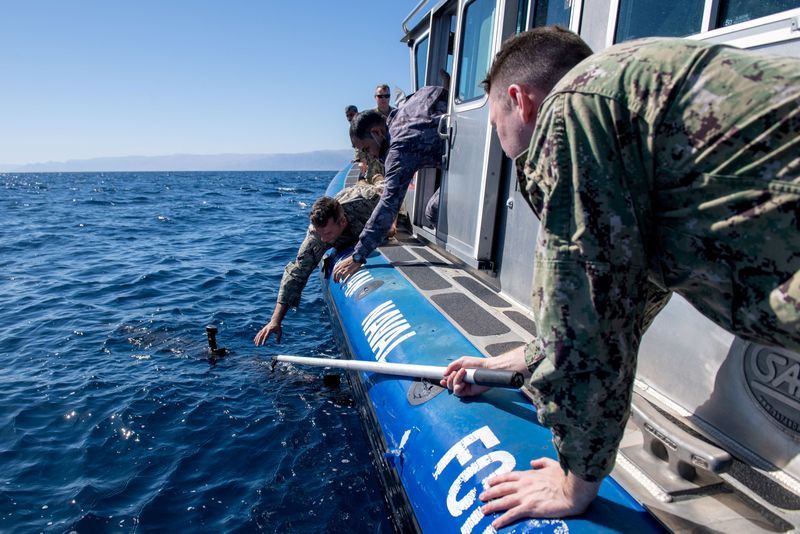 Sailors assigned to Task Force 59 and members of the Royal Jordanian Navy retrieve an Iver unmanned undersea vehicle during a 60-nation International Maritime Exercise in the Gulf of Aqaba, Jordan, Feb. 8, 2022