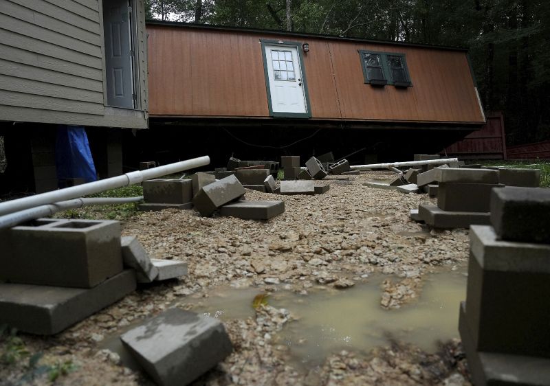 Dorothy and Earl Blevins' temporary home sits off its foundation after it was moved by flooded water and into the new home they are building on property once owned by Dorothy's mother on Sunday, in Spendora, Texas.