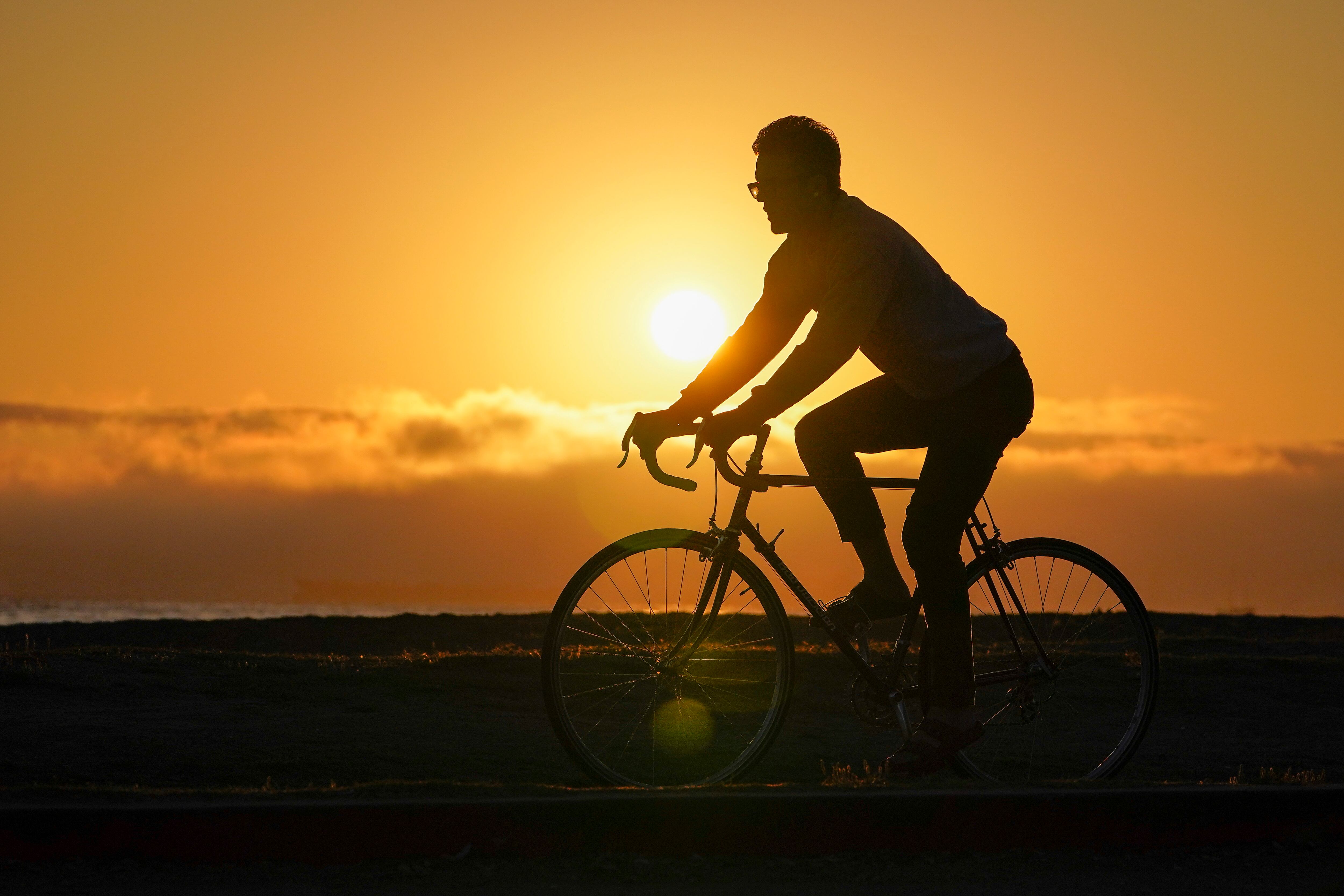 A bicyclist rides on a trail alongside the beach in Alameda, Calif., Oct. 13, 2022. High-intensity exercise and time-restricted eating may do more for cardiometabolic health and weight loss than either approach alone.