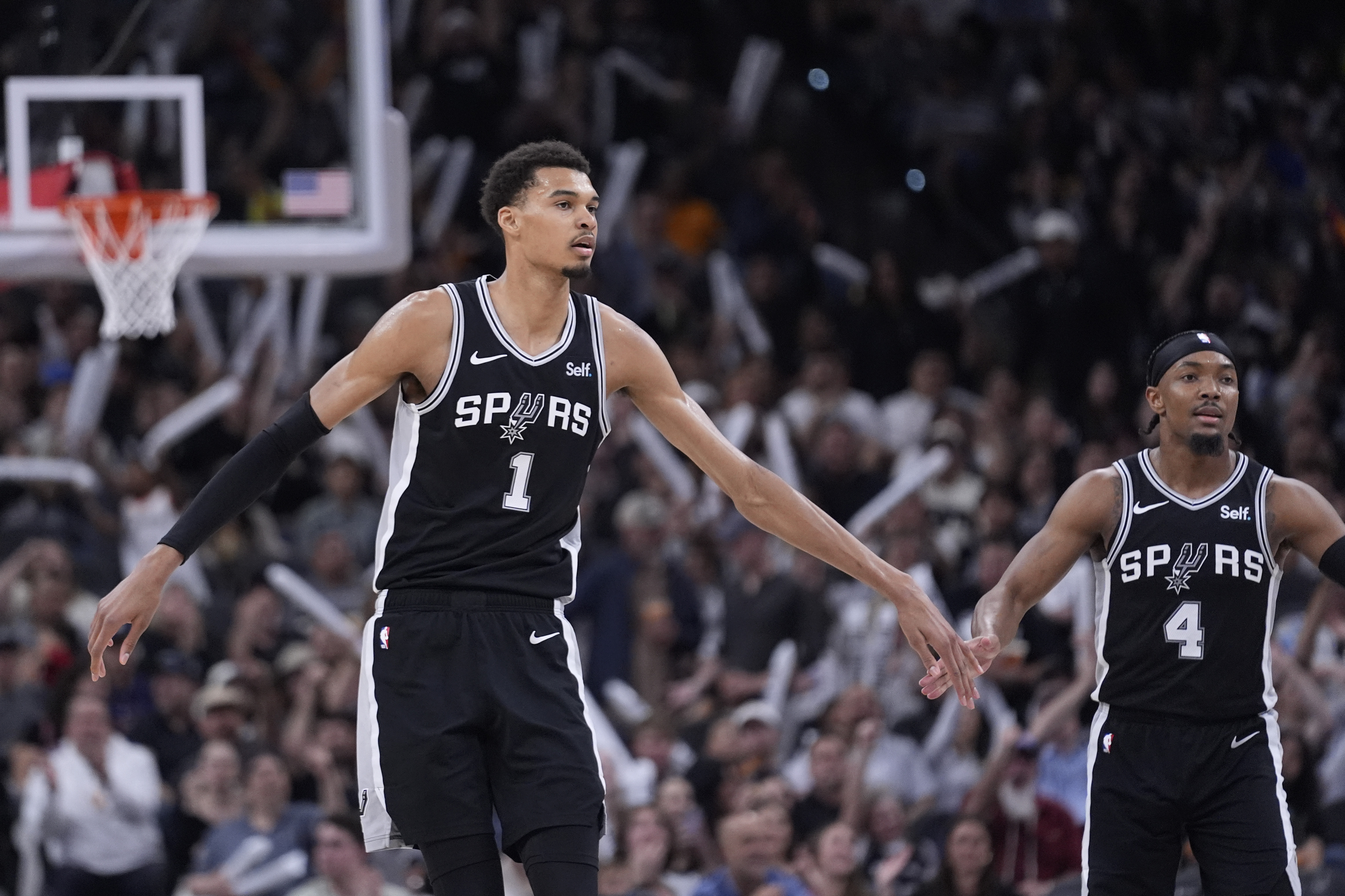 San Antonio Spurs center Victor Wembanyama (1) celebrates a score with guard Devonte' Graham (4) during the second half of an NBA basketball game against the Denver Nuggets in San Antonio, Friday, April 12, 2024.