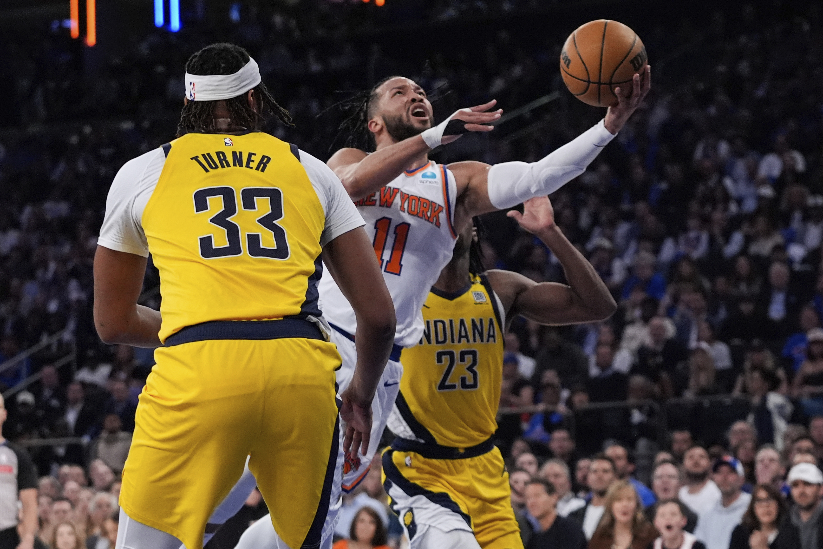 New York Knicks' Jalen Brunson (11) drives past Indiana Pacers' Myles Turner (33) and Aaron Nesmith (23) during the first half of Game 1 in an NBA basketball second-round playoff series, Monday, May 6, 2024, in New York.