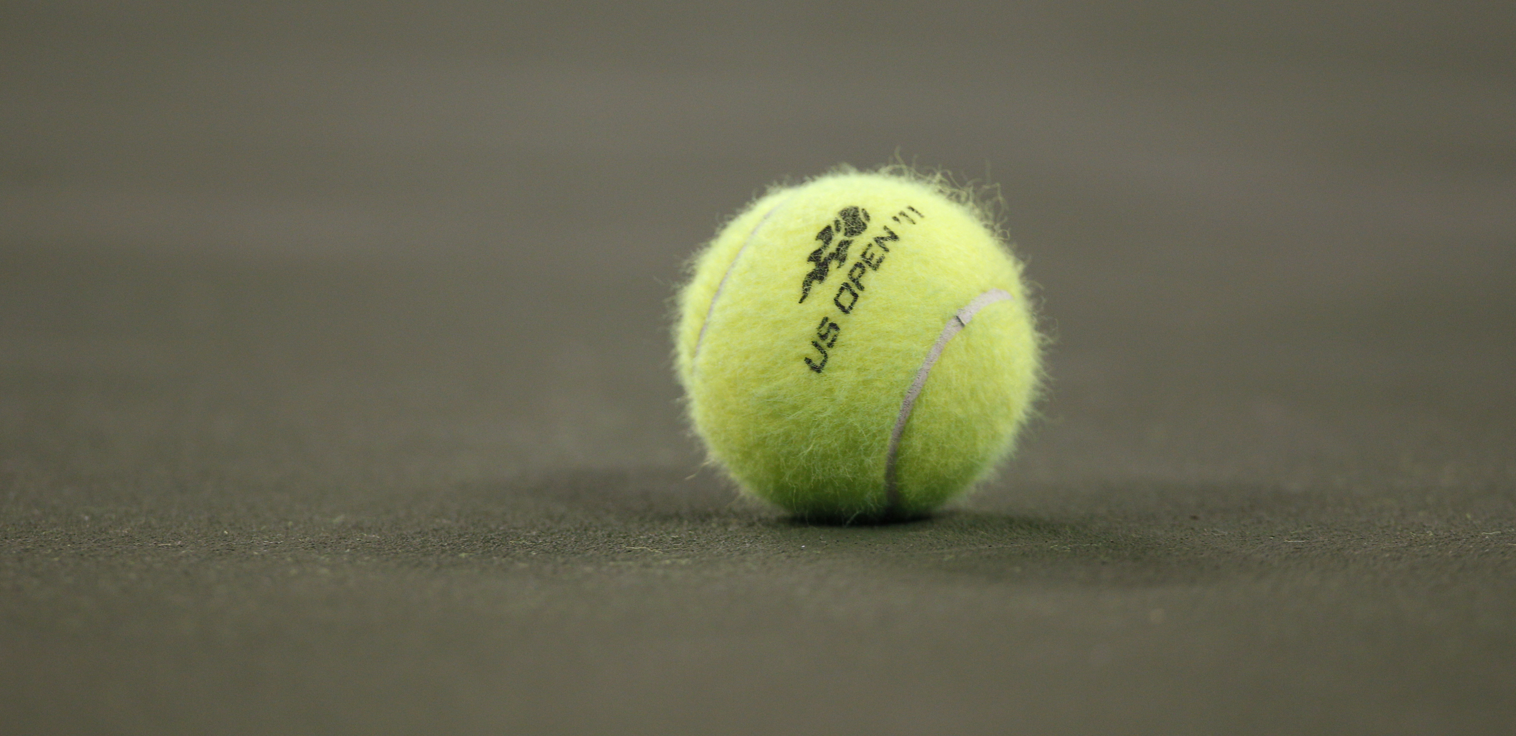 FILE - A tennis ball on the court during the first round of the U.S. Open tennis tournament in New York, Tuesday, Aug. 30, 2011. A tennis player has been awarded $9 million in damages by a jury in federal court in Florida after accusing the U.S. Tennis Association of failing to protect her from a coach she said sexually abused her at one of its training centers when she was 19.