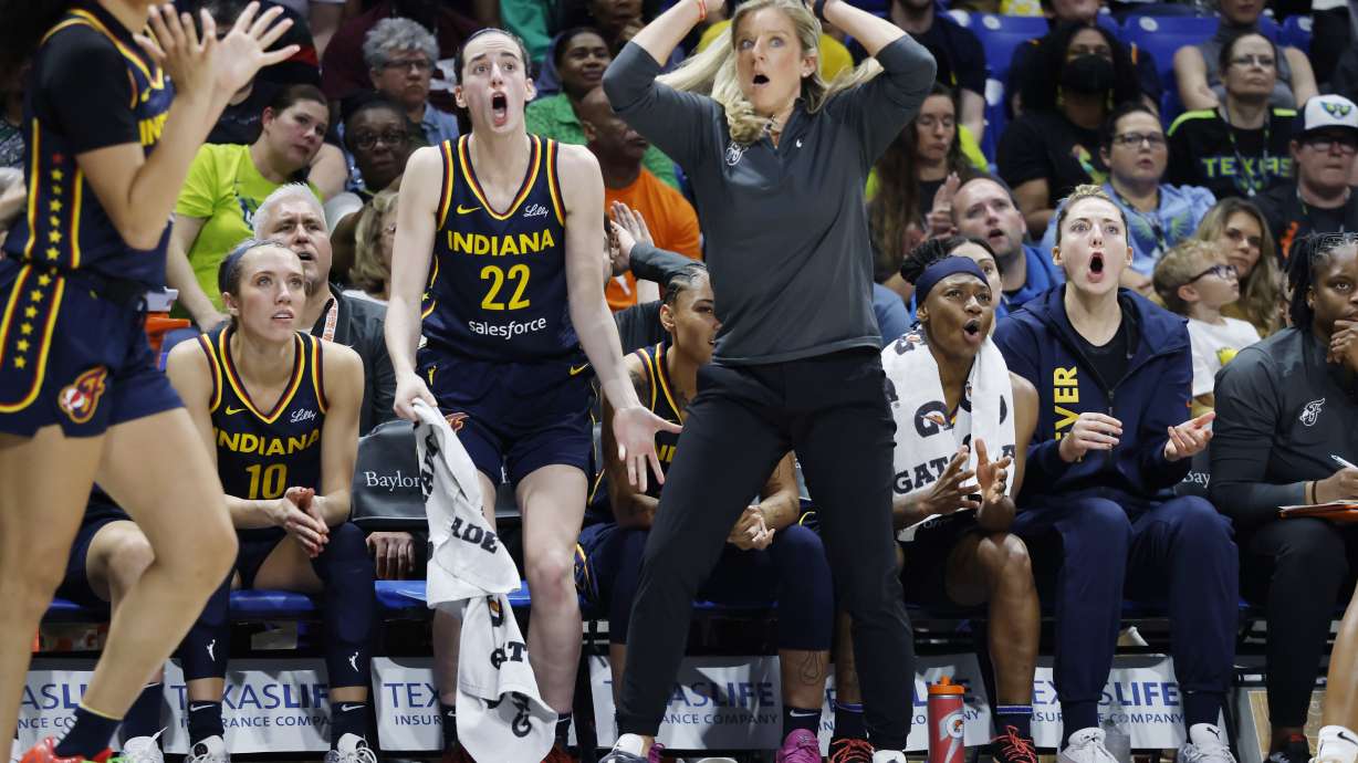 Indiana Fever guard Caitlin Clark (22) and head coach Christine Sides, center right, react after a play during the second half of an WNBA basketball game against the Dallas Wings in Arlington, Texas, Friday, May 3, 2024.
