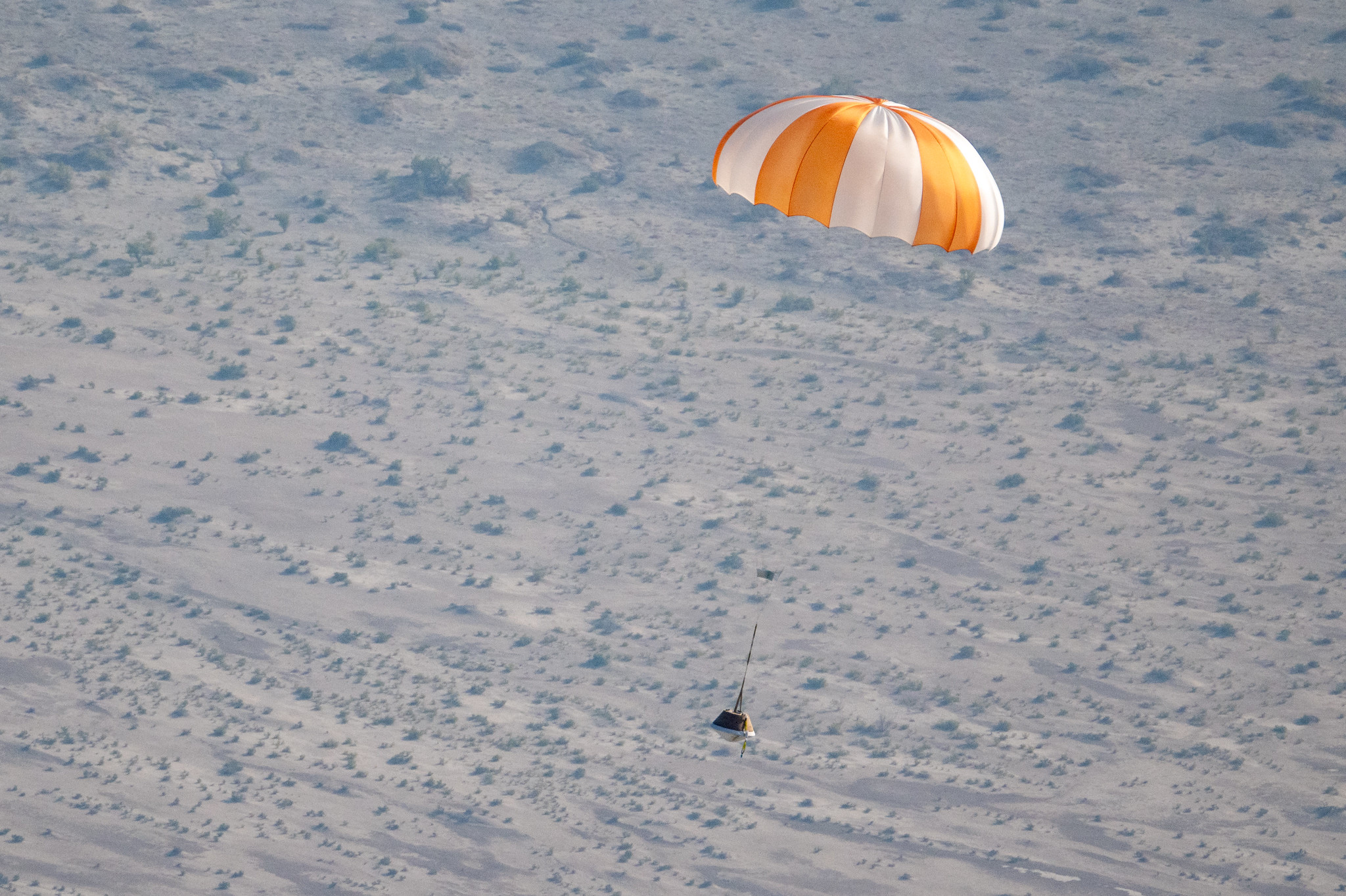 A training model of the sample return capsule is seen is seen during a drop test in preparation for the retrieval of the sample return capsule from NASA's OSIRIS-REx mission, Wednesday, Aug. 30, 2023, at the Department of Defense's Utah Test and Training Range.