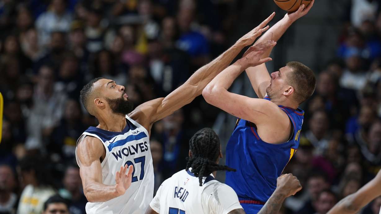 Minnesota Timberwolves center Rudy Gobert, left, goes up to block a shot by Denver Nuggets center Nikola Jokic, right, as Timberwolves center Naz Reid (11) looks on in the second half of Game 1 of an NBA basketball second-round playoff series Saturday, May 4, 2024, in Denver.