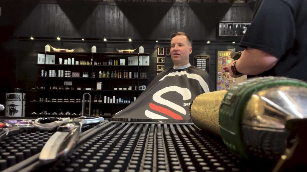 Utah County sheriff's deputy Bryce Penrod gets his hair cut at The Good Fellas Barber Shop in Spanish Fork on Tuesday.
