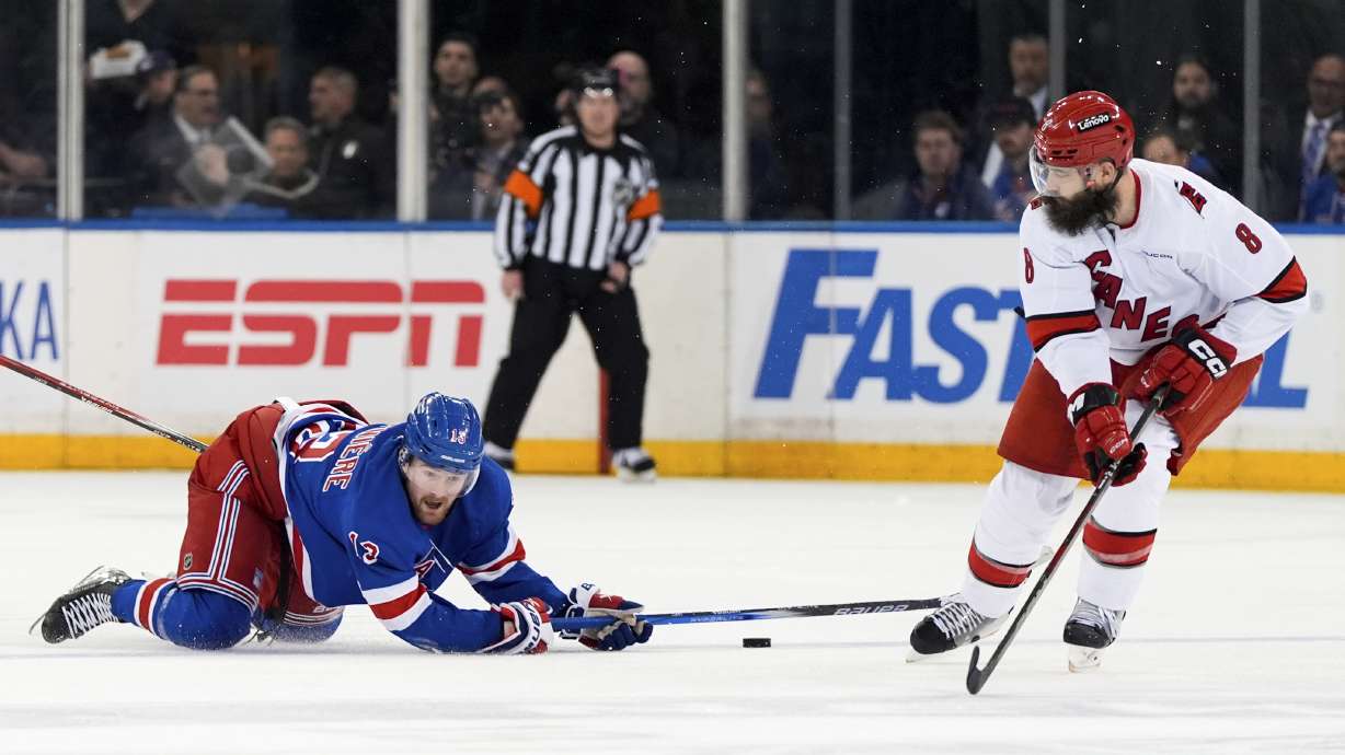 New York Rangers left wing Alexis Lafrenière (13) and Carolina Hurricanes defenseman Brent Burns (8) vie for the puck during the second period in Game 2 of an NHL hockey Stanley Cup second-round playoff series Tuesday, May 7, 2024, in New York.