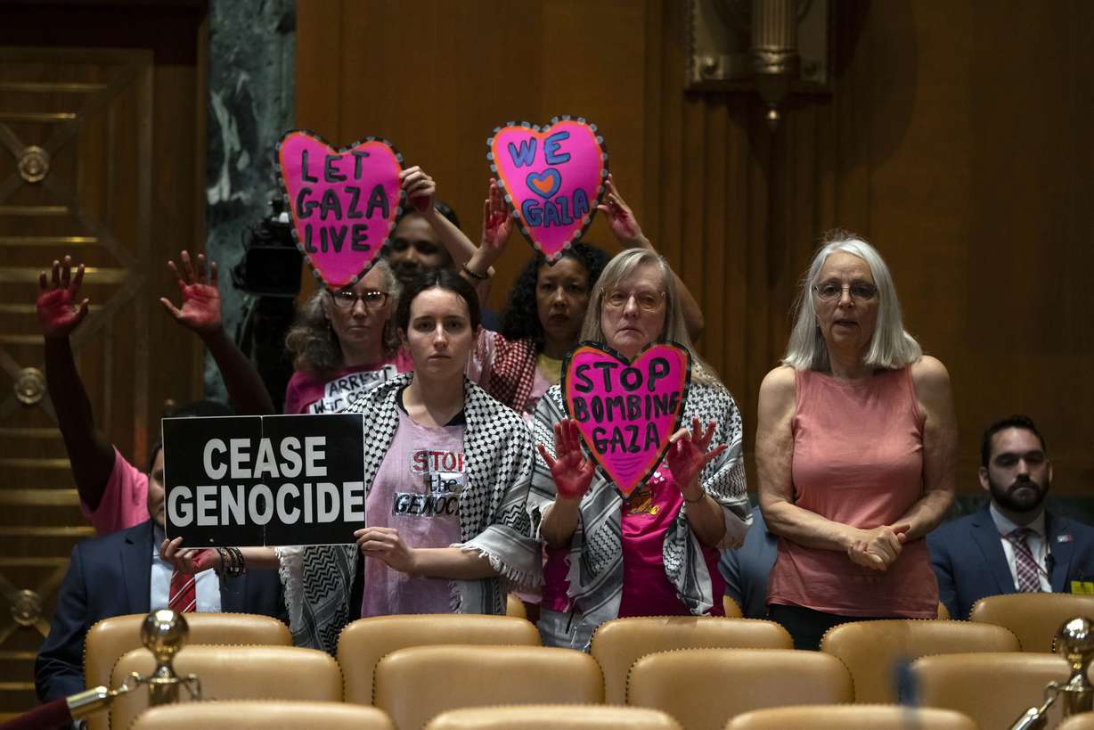 Protestors opposed to the war between Israel and Hamas stand before a hearing of the Senate Appropriations Committee Subcommittee on Defense with Secretary of Defense Lloyd Austin and Chairman of the Joint Chiefs of Staff Air Force Gen. CQ Brown on Capitol Hill, Wednesday, in Washington.