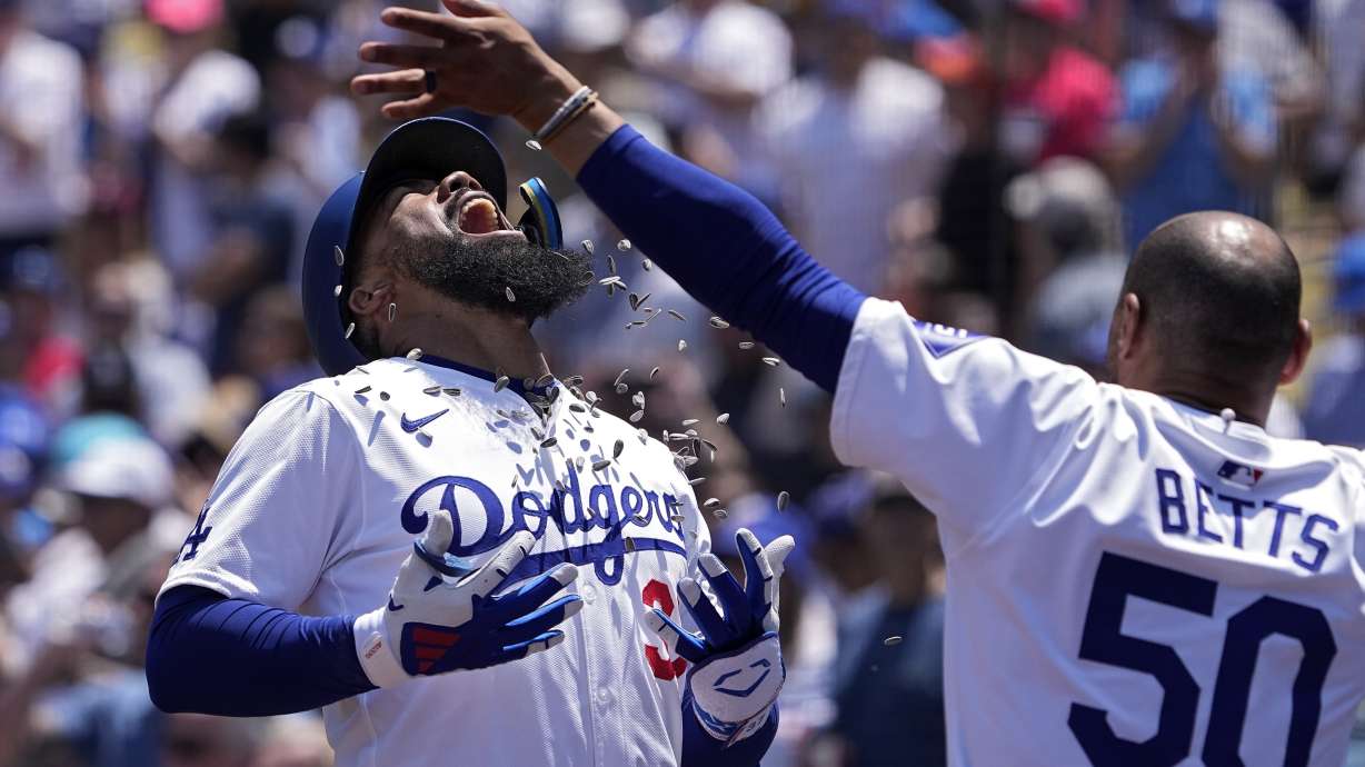 Los Angeles Dodgers' Teoscar Hernández, left, is hit with sunflower seeds thrown by Mookie Betts after hitting a two-run home run during the sixth inning of a baseball game against the Miami Marlins Wednesday, May 8, 2024, in Los Angeles.
