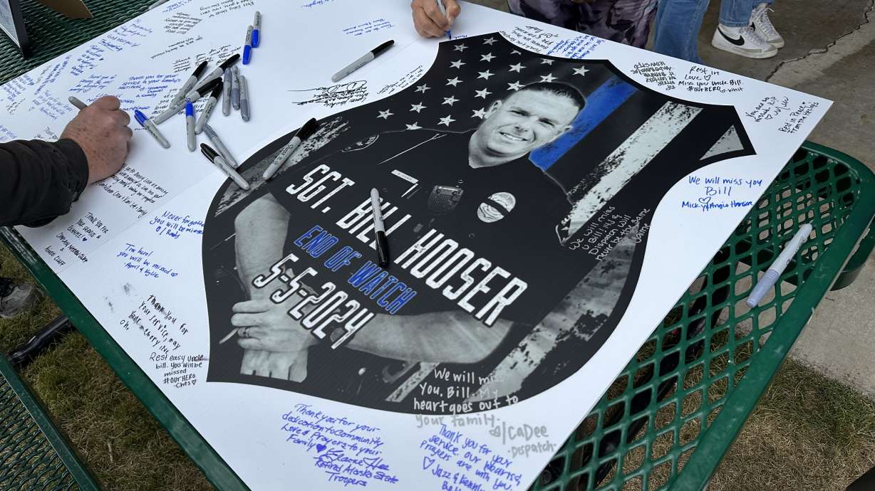 Attendees sign a card at a 2024 vigil for slain Santaquin Police Sgt. Bill Hooser. The City Council recently voted in favor of designating the month of May each year to honor his service.