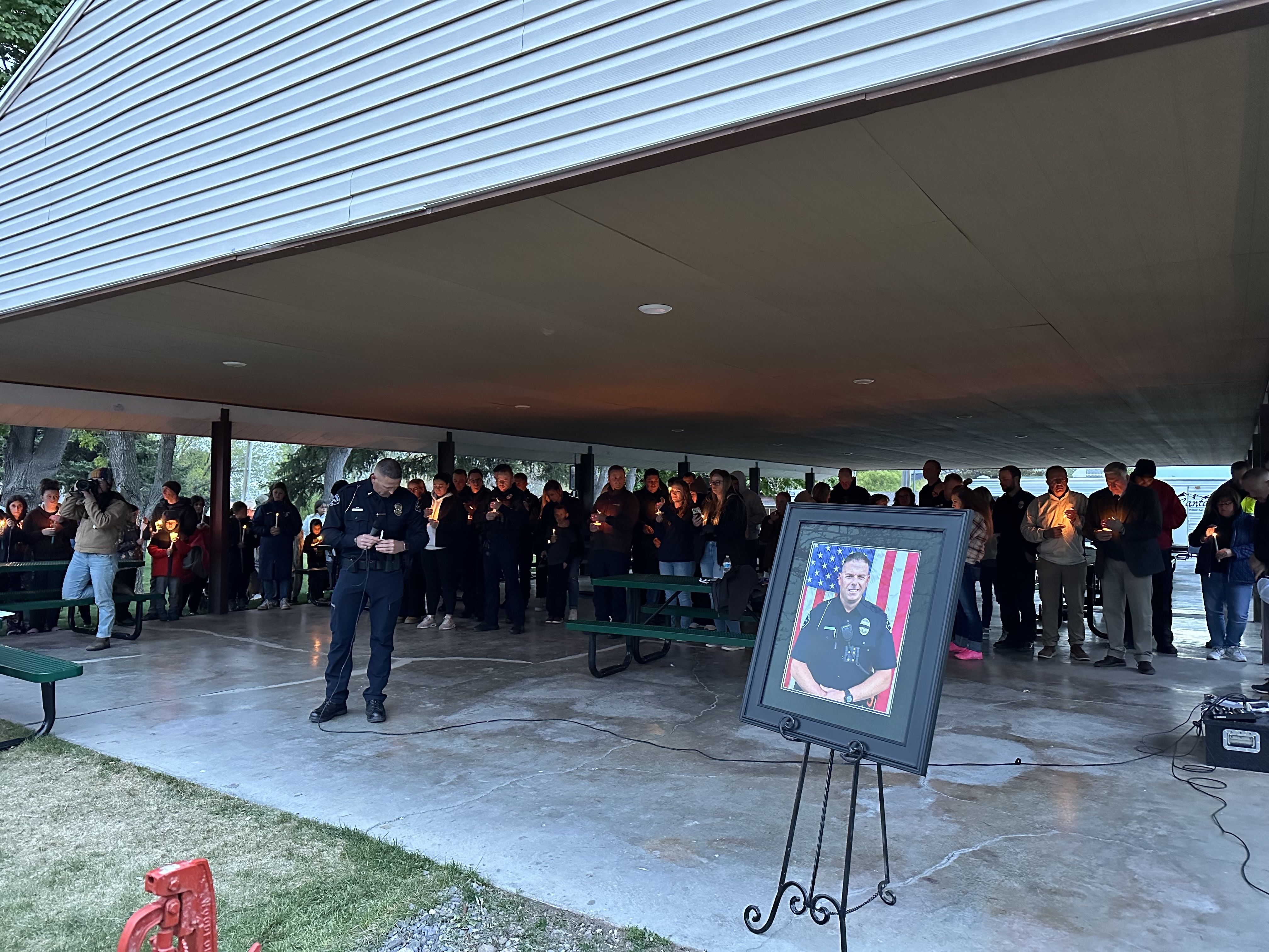 Santaquin Police Lt. Mike Wall holds a candle during a moment of silence at a vigil at Centennial Park Wednesday night in Santaquin for Sgt. Bill Hooser who was killed in the line of duty.