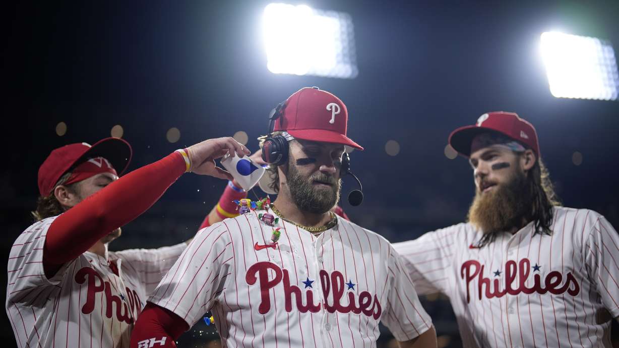 Philadelphia Phillies' Bryce Harper, center, celebrates with Bryson Stott, left, and Brandon Marsh after the Phillies won a baseball game against the Toronto Blue Jays, Tuesday, May 7, 2024, in Philadelphia.