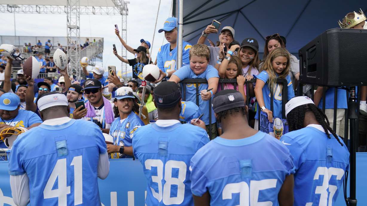 FILE - Los Angeles Chargers safety Raheem Layne (41), cornerback Cam Brown (38), cornerback Amechi Uzodinma (35) and cornerback Ja'Sir Taylor (36) sign autographs for fans during the NFL football team's training camp, Saturday, July 29, 2023, in Costa Mesa, Calif. For at least one year, Southern California will be a prime spot for NFL training camps. With the Costa Mesa City Council unanimously approving a deal with the Las Vegas Raiders, five teams, the Raiders, Chargers, Rams, Saints and Cowboys, will be holding their practices within a 105-mile radius in late July and early August.