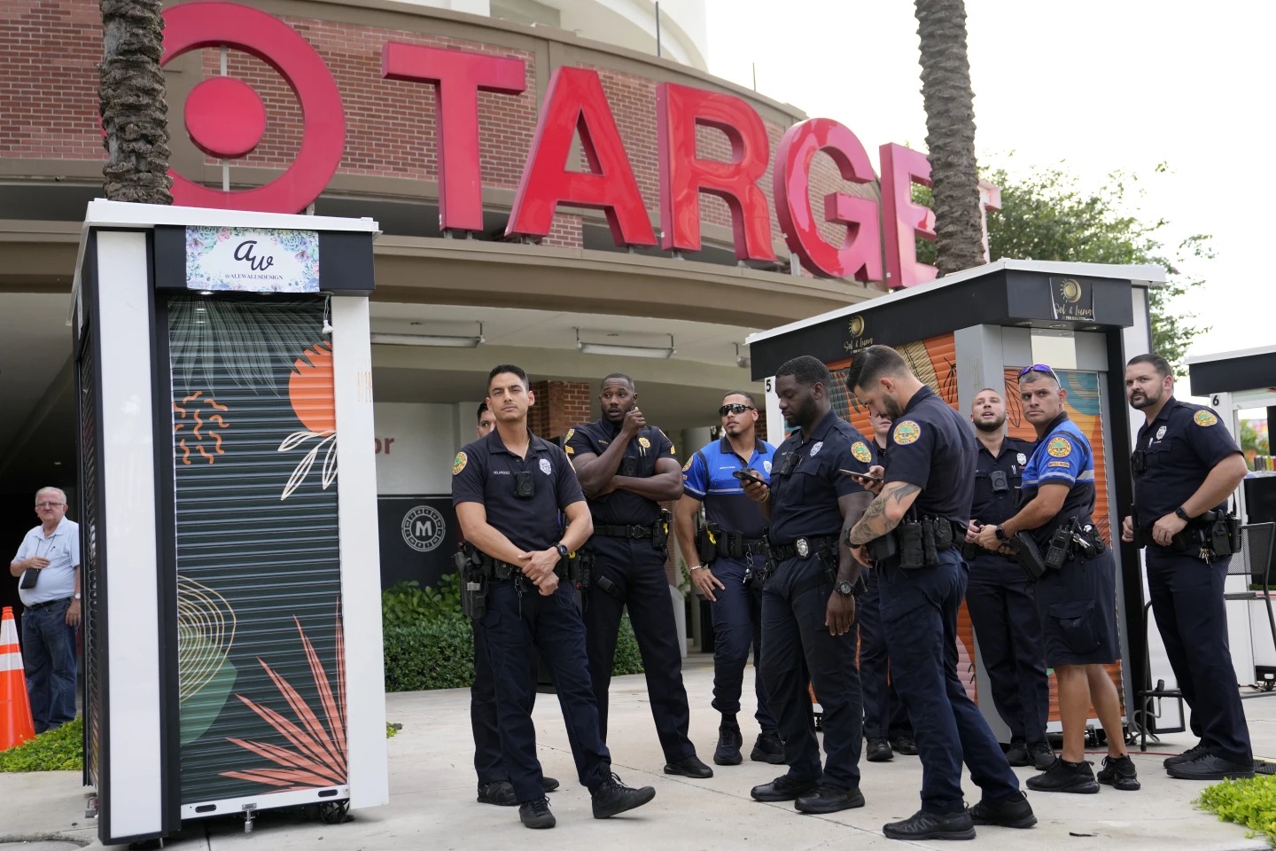 Police officers stand outside of a Target store as a group of people protest June 1, 2023, in Miami. Target confirmed that it won't be carrying its LGBTQ+ merchandise for Pride month in June in some stores.