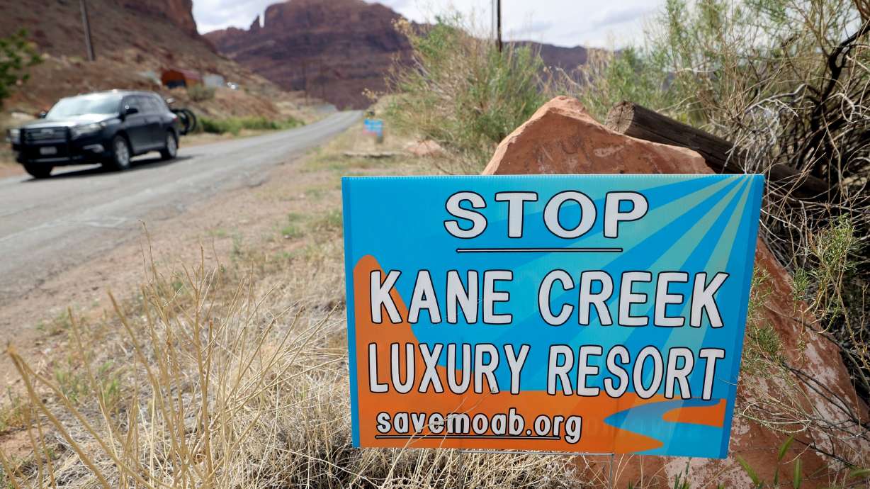 Signs are posted along Kane Creek Bouldevard protesting the Kane Creek development near Moab on Friday. Developers plan to build around 580 residential and commercial units in a floodplain along the Colorado River.