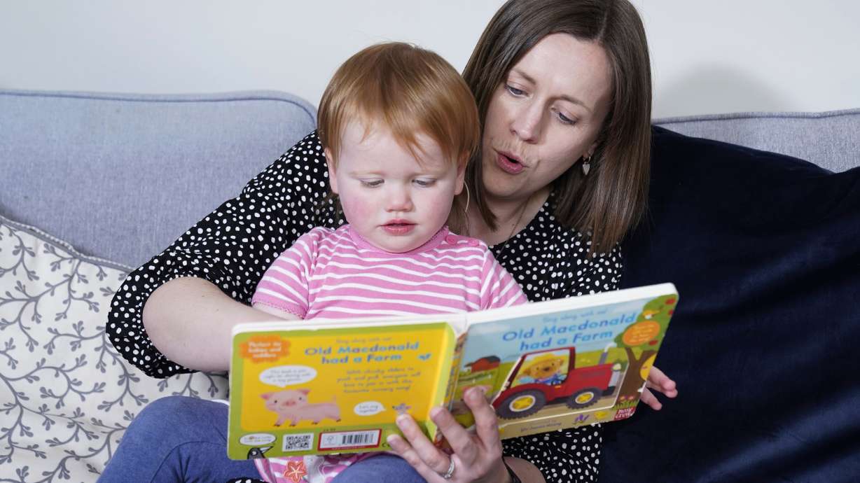 Opal Sandy was born deaf because of a rare genetic condition and can now hear unaided for the first time after receiving groundbreaking gene therapy at 11 months old. She reads with her mother, Jo, at their home in Eynsham, Oxfordshire.