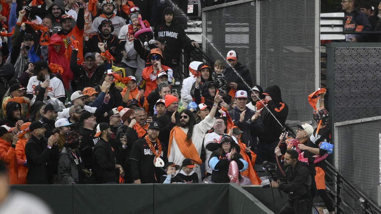 Baltimore Orioles owner David Rubenstein (wearing white cap), lower right, sprays the crowd during a baseball game between the Orioles and the Arizona Diamondbacks, Friday, May 10, 2024, in Baltimore.