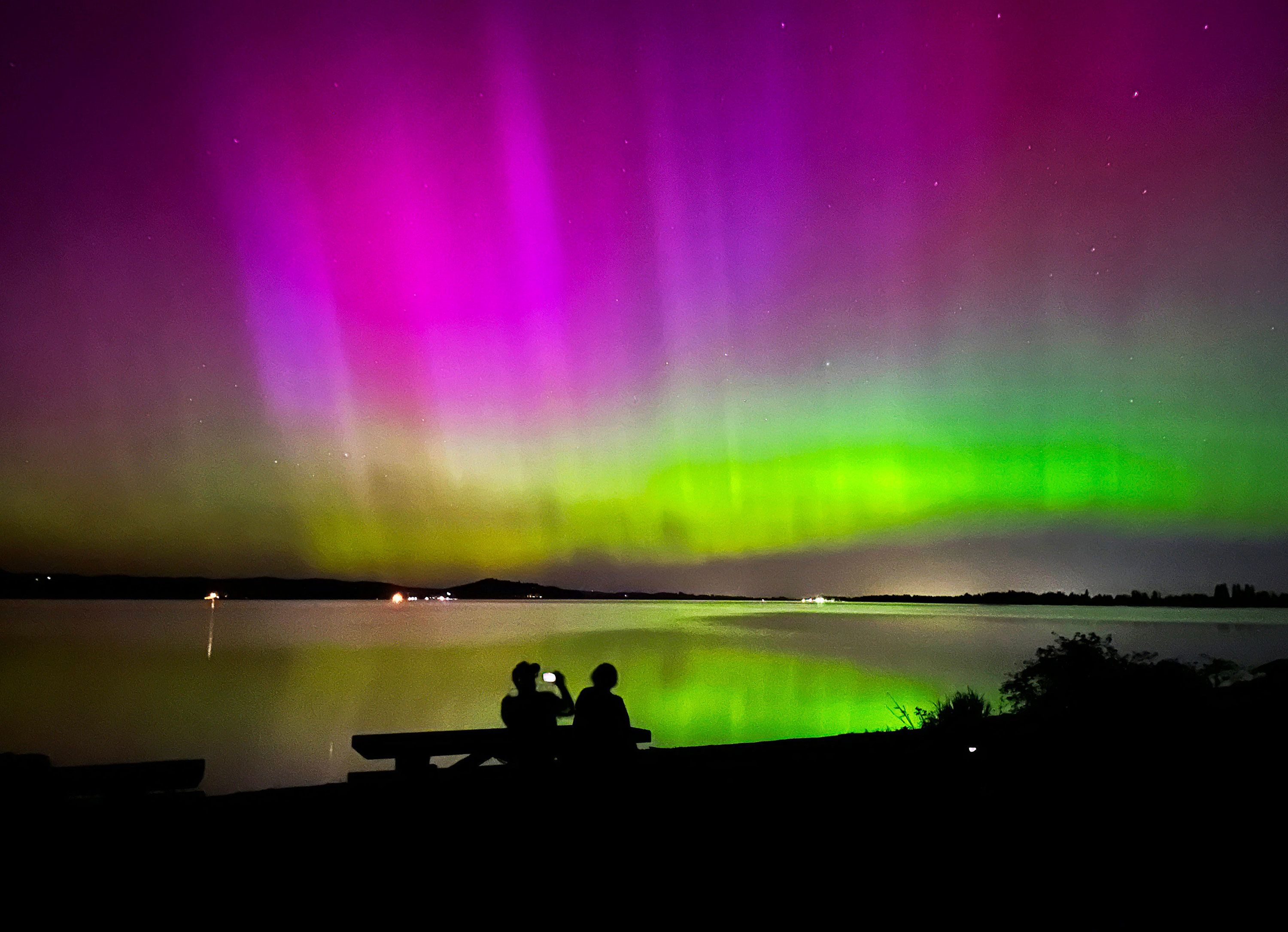 Marshall Falcon, left, photographs the northern lights as he and Angie Avitia watch the celestial display from Perkins Peninsula Park, west of Eugene, Oregon, on Friday. A second chance to view the magnificent auroras will arrive Saturday evening.