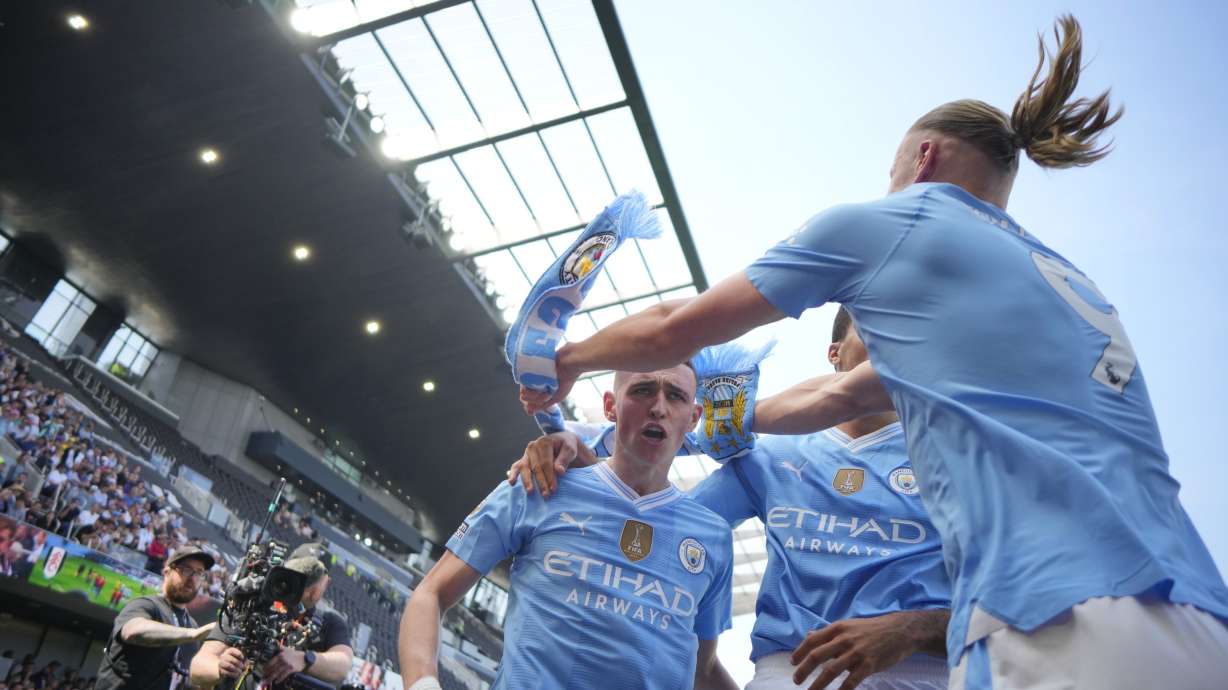 Manchester City's Phil Foden, centre, celebrates with teammates after scoring his side's second goal during the English Premier League soccer match between Fulham and Manchester City at the Craven Cottage Stadium in London, Saturday, May 11, 2024.
