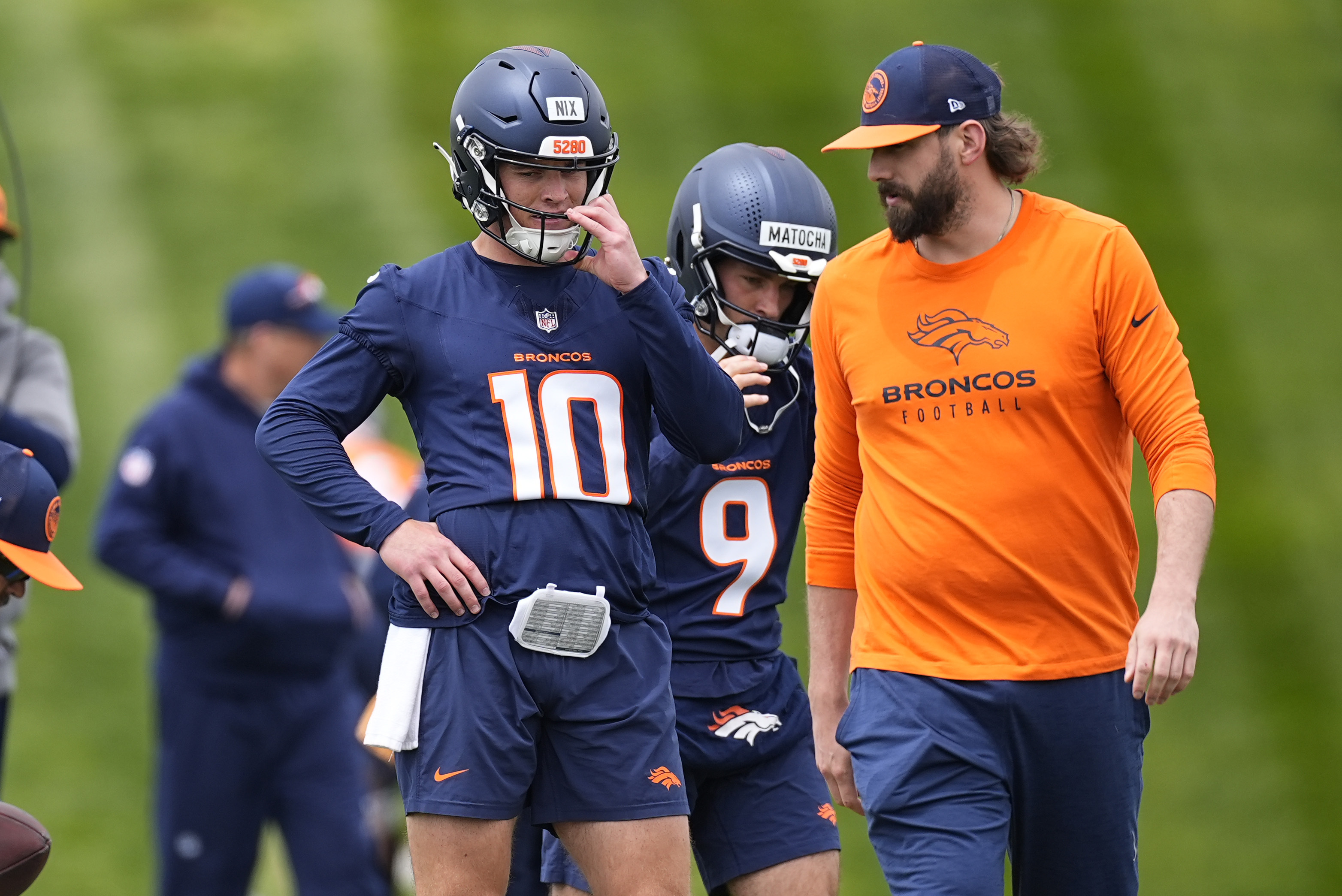 Denver Broncos quarterback Bo Nix, left, confers with quarterback coach Davis Webb during the NFL football team's rookie minicamp, Saturday, May 11, 2024, in Centennial, Colo. 