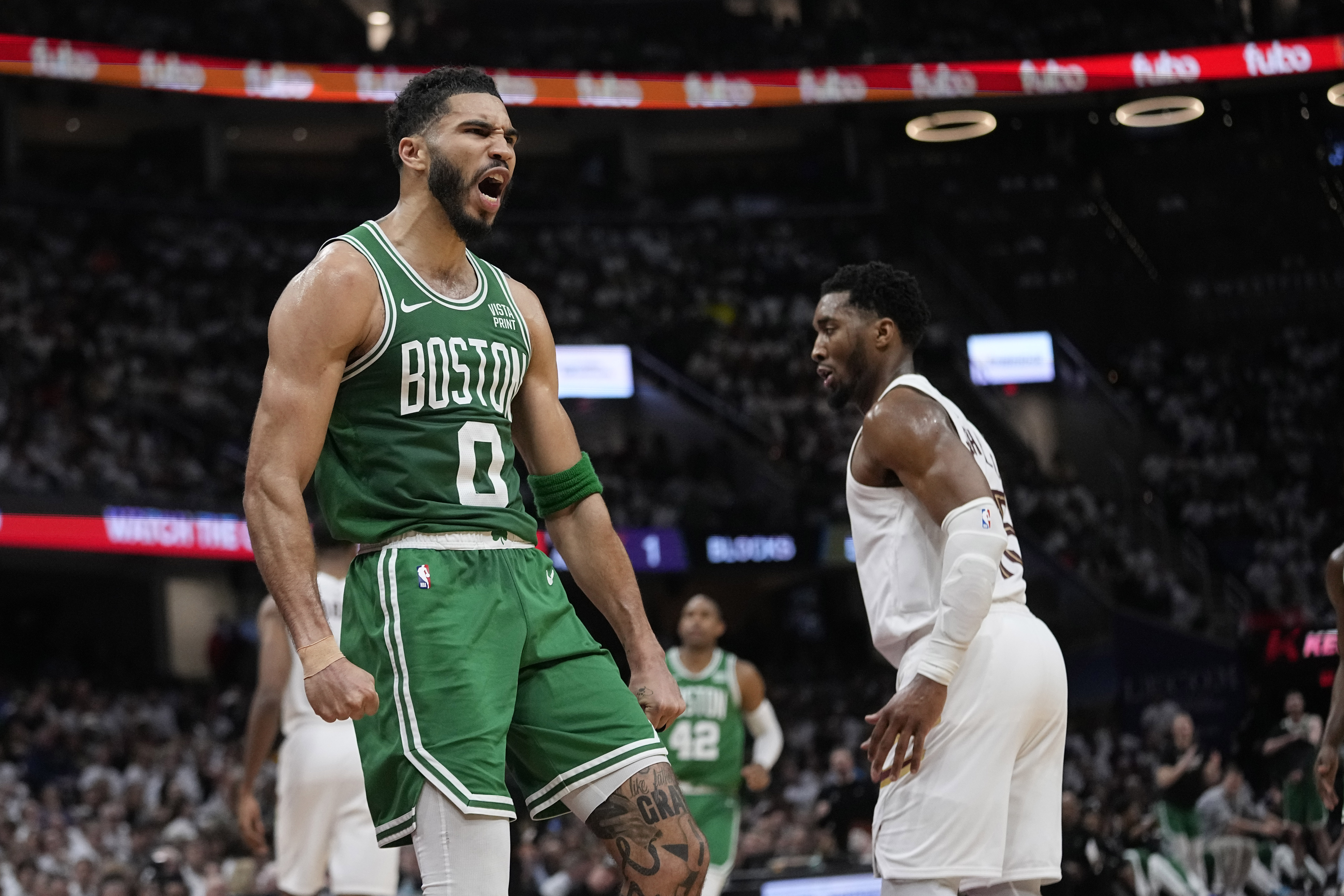Boston Celtics forward Jayson Tatum (0) celebrates near Cleveland Cavaliers guard Donovan Mitchell, right, after a dunk during the second half of Game 3 of an NBA basketball second-round playoff series Saturday, May 11, 2024, in Cleveland. 