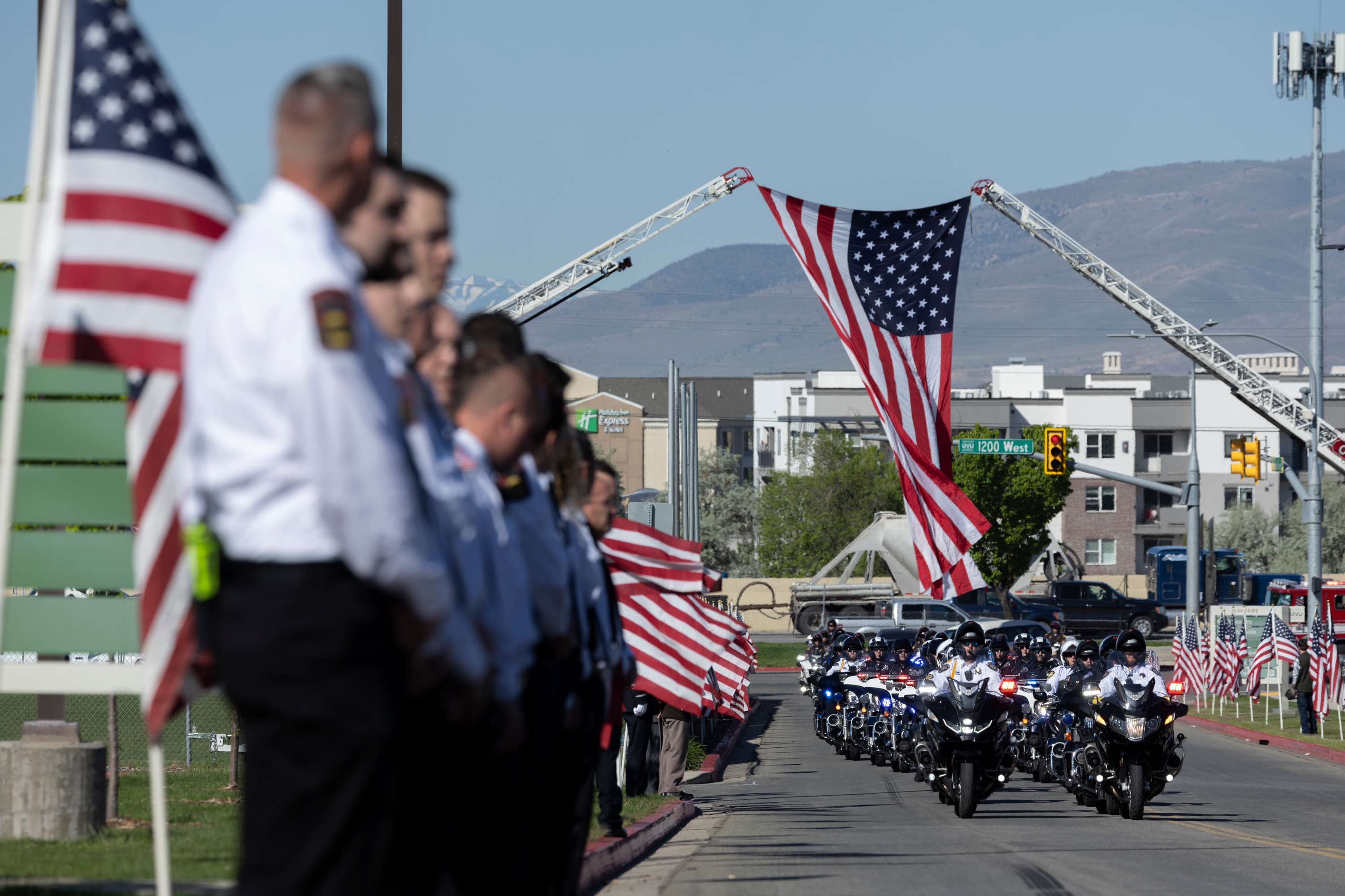 Law enforcement arrives escorting the hearse for Santaquin Police Sgt. Bill Hooser’s funeral at UCCU Center for in Orem on Monday.