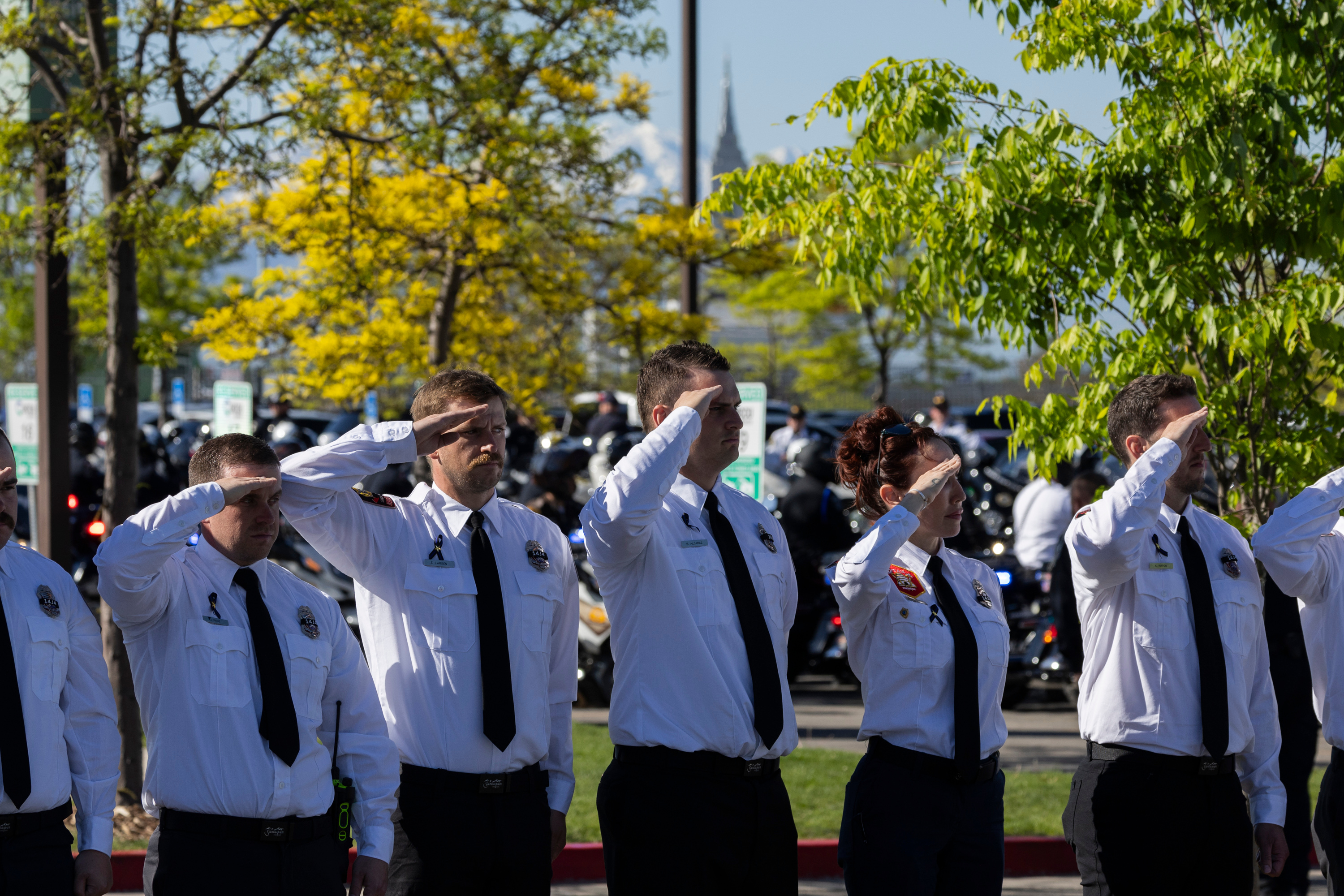 Members of Santaquin Fire and EMS salute as a procession arrives at the UCCU Center for Santaquin Sgt. Bill Hooser’s funeral in Orem on Monday.