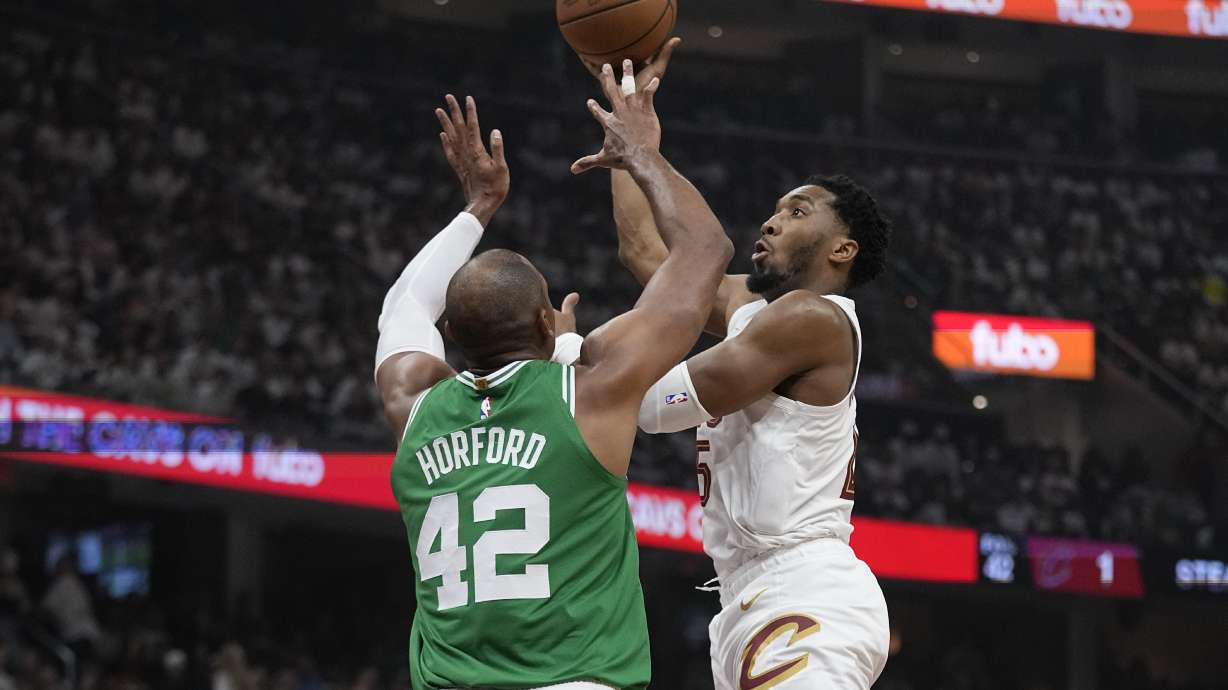 Cleveland Cavaliers guard Donovan Mitchell, right, shoots over Boston Celtics center Al Horford (42) during the first half of Game 3 of an NBA basketball second-round playoff series Saturday, May 11, 2024, in Cleveland.