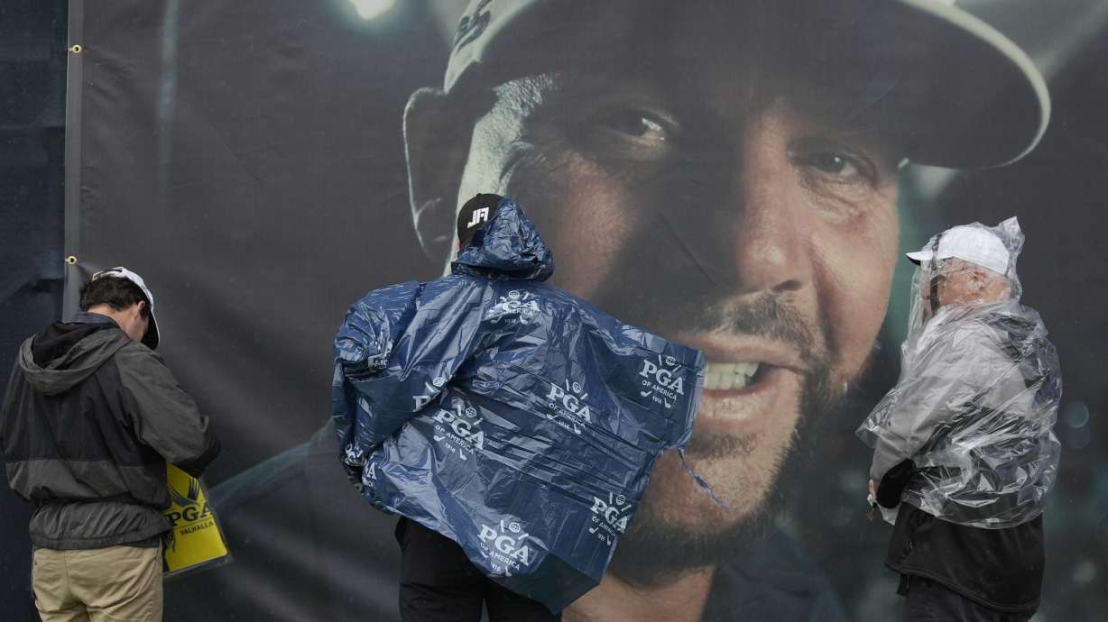 Fans leaves the course past a banner of club pro Michael Block after weather delay during a practice round for the PGA Championship golf tournament at the Valhalla Golf Club, Tuesday, May 14, 2024, in Louisville, Ky.