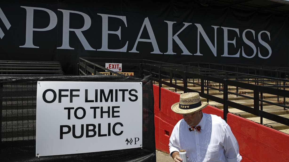 FILE - A spectator walks past a closed section of grandstands at Pimlico Race Course ahead of the Black Eyed Susan horse race, May 17, 2019, in Baltimore. The storied but decaying home of the second jewel of the Triple Crown, Pimlico Race Course, is finally on the verge of much-needed repairs. The Preakness on Saturday, May 18, 2024 will be the last before work begins, with the race in 2025 set to be run mid-construction before moving to Laurel Park in 2026 and returning.