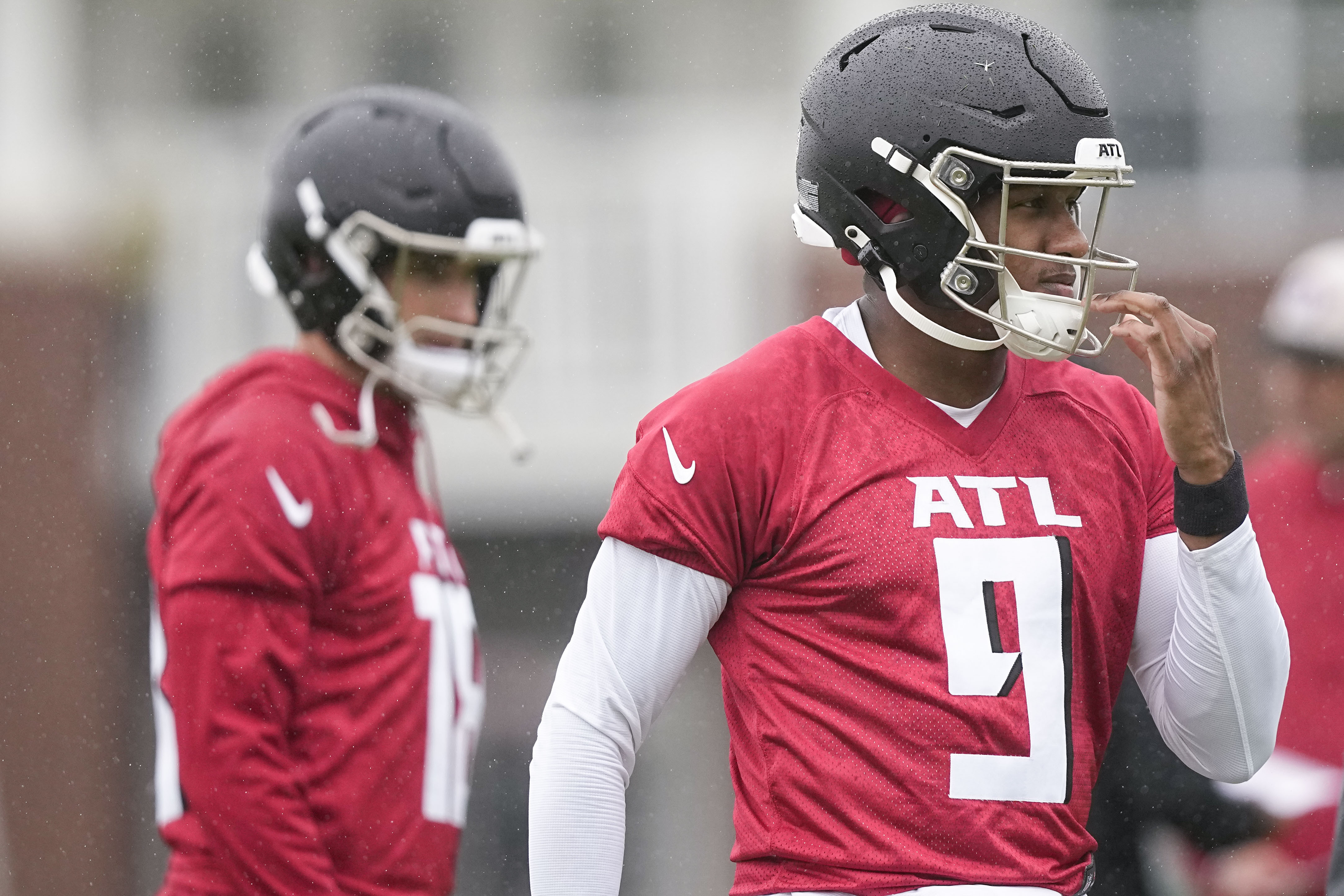Atlanta Falcons quarterbacks Michael Penix Jr., right, and Kirk Cousins, left, run drills during an NFL football mini training camp practice on Tuesday, May 14, 2024, in Flowery Branch, Ga. 